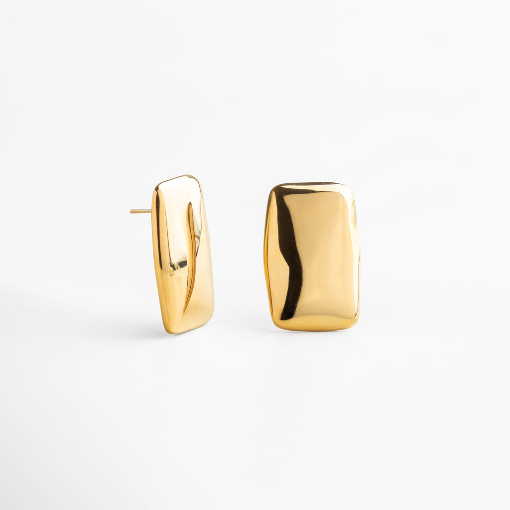 aretes dorados con diseño rectangular, proporciones delicadas y versátiles, escala real para referencia de tamaño, joyería atemporal que aporta un detalle sofisticado y elegante