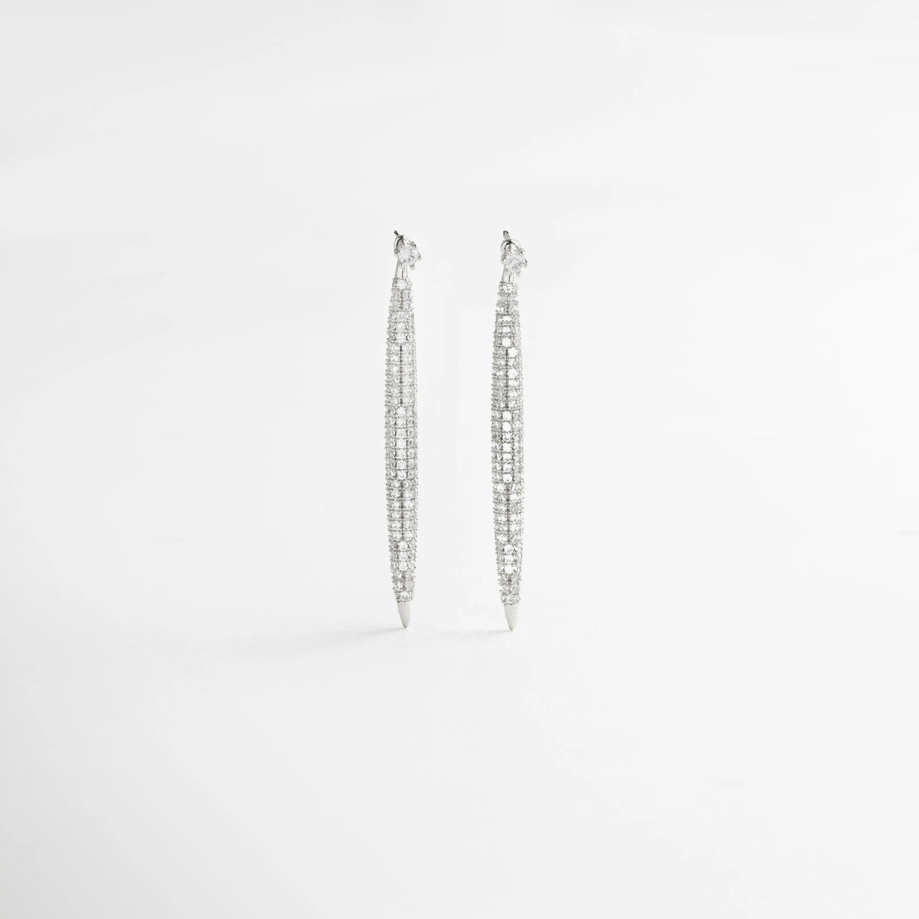 aretes largos vista frontal, joyería plateada minimal, aretes elegantes mujer, accesorios plateados sofisticados, aretes colgantes chic, joyería femenina luminosa, aretes finos plateados, aretes modernos