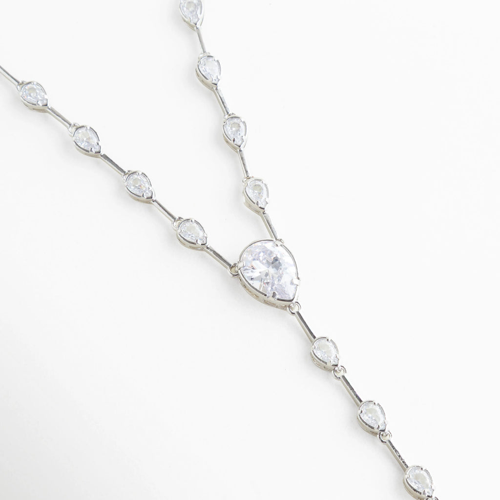 Detalle de cadena plateada con zirconias ovaladas incrustadas, Close up de collar con piedras brillantes tipo diamante, Cadena delicada con incrustaciones de zirconia y acabado en oro blanco, Detalle de eslabones con cristales brillantes en collar elegante, Vista cercana de zirconias en cadena fina plateada