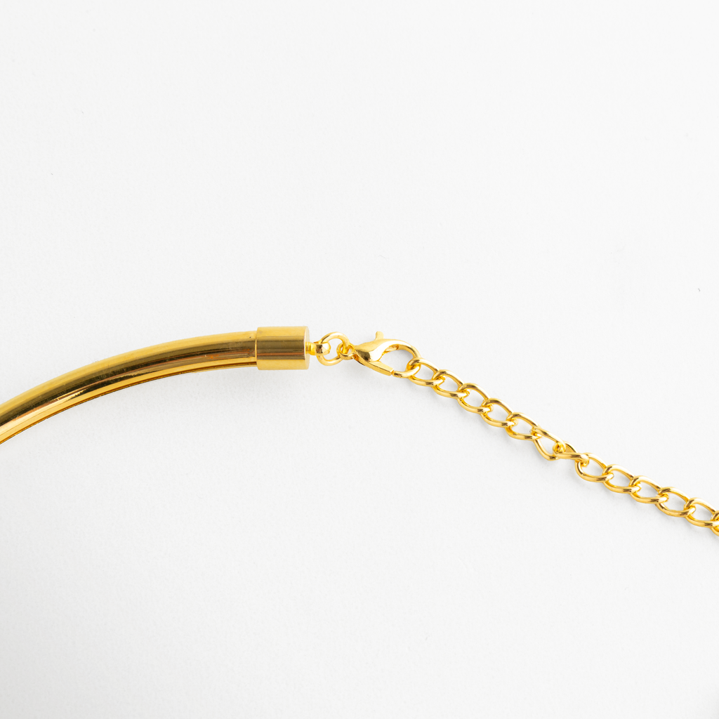 Detalle del Golden Aureva con cadena de ajuste y acabado dorado brillante, Vista cercana del sistema de ajuste del collar rígido dorado, Detalle de collar dorado con cadena fina ajustable y diseño elegante, Close up del ajuste metálico del Golden Aureva en tono oro,  Detalle del acabado pulido y ajuste delicado del collar dorado.