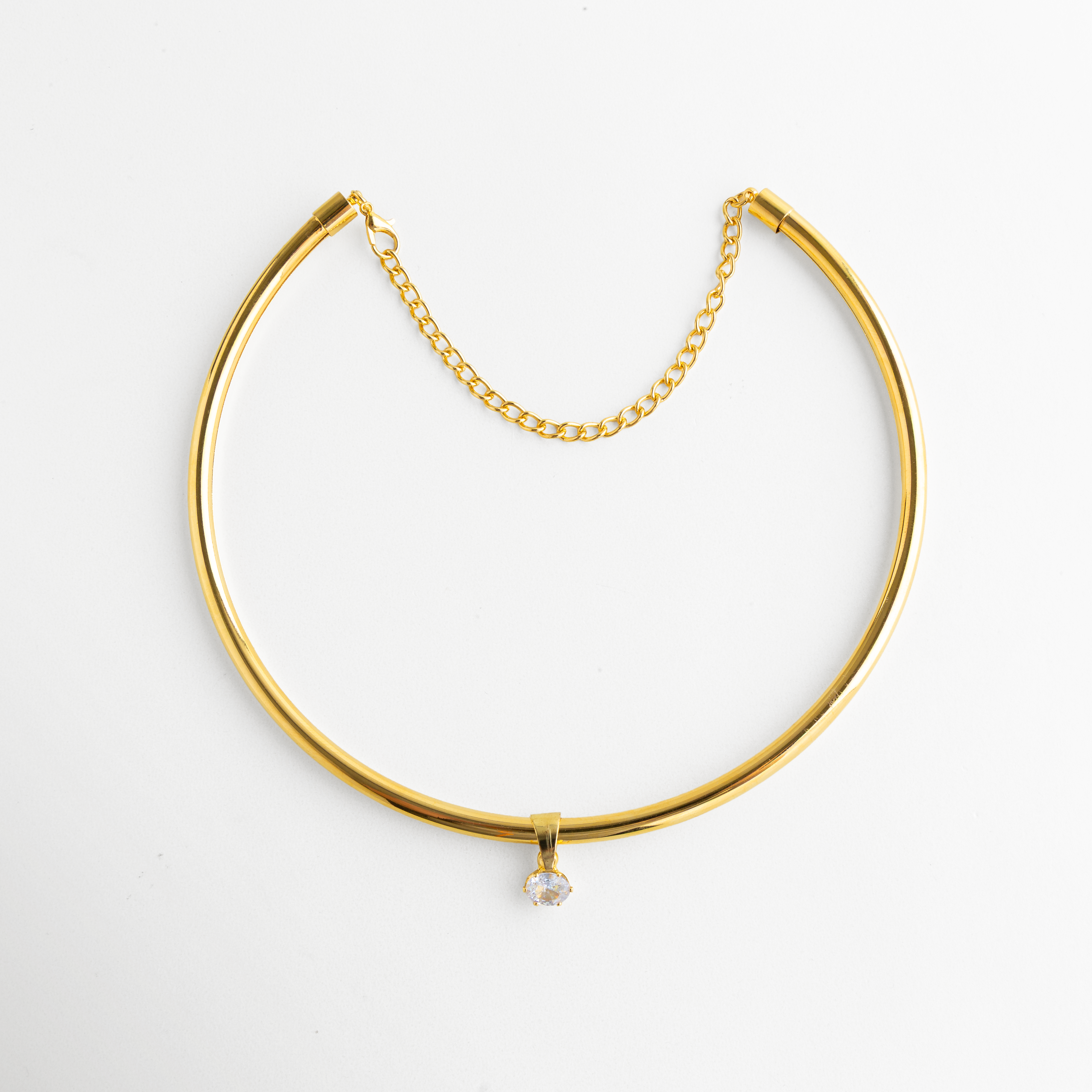 Vista completa de Golden Aureva con estructura rígida dorada y cadena fina de ajuste, Collar dorado elegante con silueta alargada y acabado sofisticado, Diseño de collar rígido en tono oro con estilo limpio y contemporáneo, Collar minimalista dorado con caída estilizada y presencia refinada, Golden Aureva en vista extendida con acabado pulido y estética moderna.