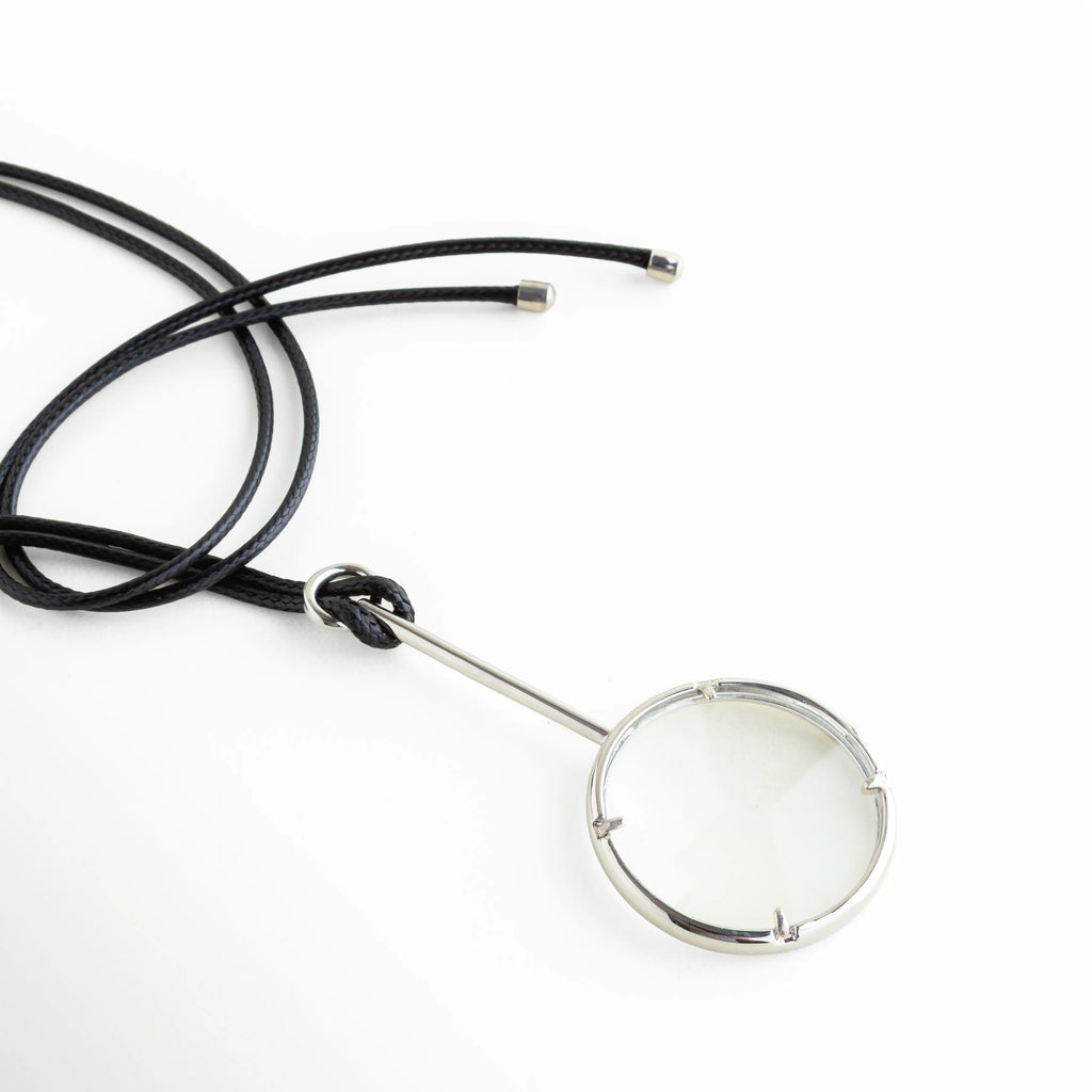 Collar con cuerda de cuero negro y nudo ajustable, Detalle cordón de cuero con cierre tipo nudo, Collar largo con ajuste libre cuerda negra, Sistema de nudo en collar de cuero estilo casual, Cuerda de cuero negro con terminaciones metálicas