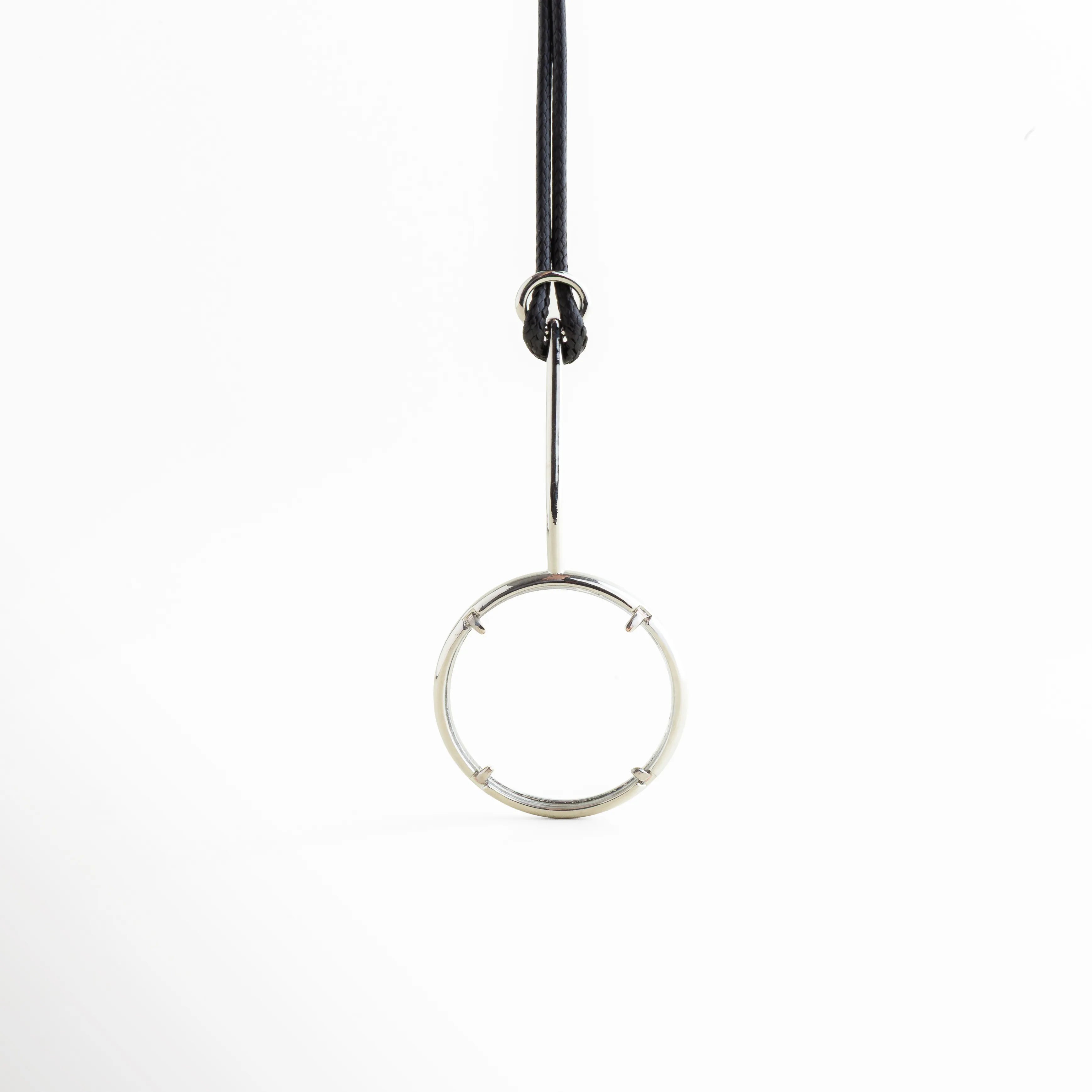 Dije lupa redondo con marco metálico acabado brillante, Colgante lupa detalle frontal diseño elegante, Lupa colgante con aro metálico estilo minimalista, Detalle dije lupa circular con acabado pulido, Colgante lupa moderno con estructura metálica