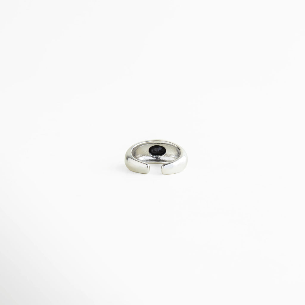 Vista superior del Anillo Callum con zirconia negra central y acabado brillante, Anillo elegante plateado visto desde arriba con piedra negra incrustada, Diseño superior del Anillo Callum con forma limpia y detalle sofisticado, Anillo ajustable con zirconia negra y estilo minimalista contemporáneo, Vista cenital de anillo brillante con acento oscuro y refinado.