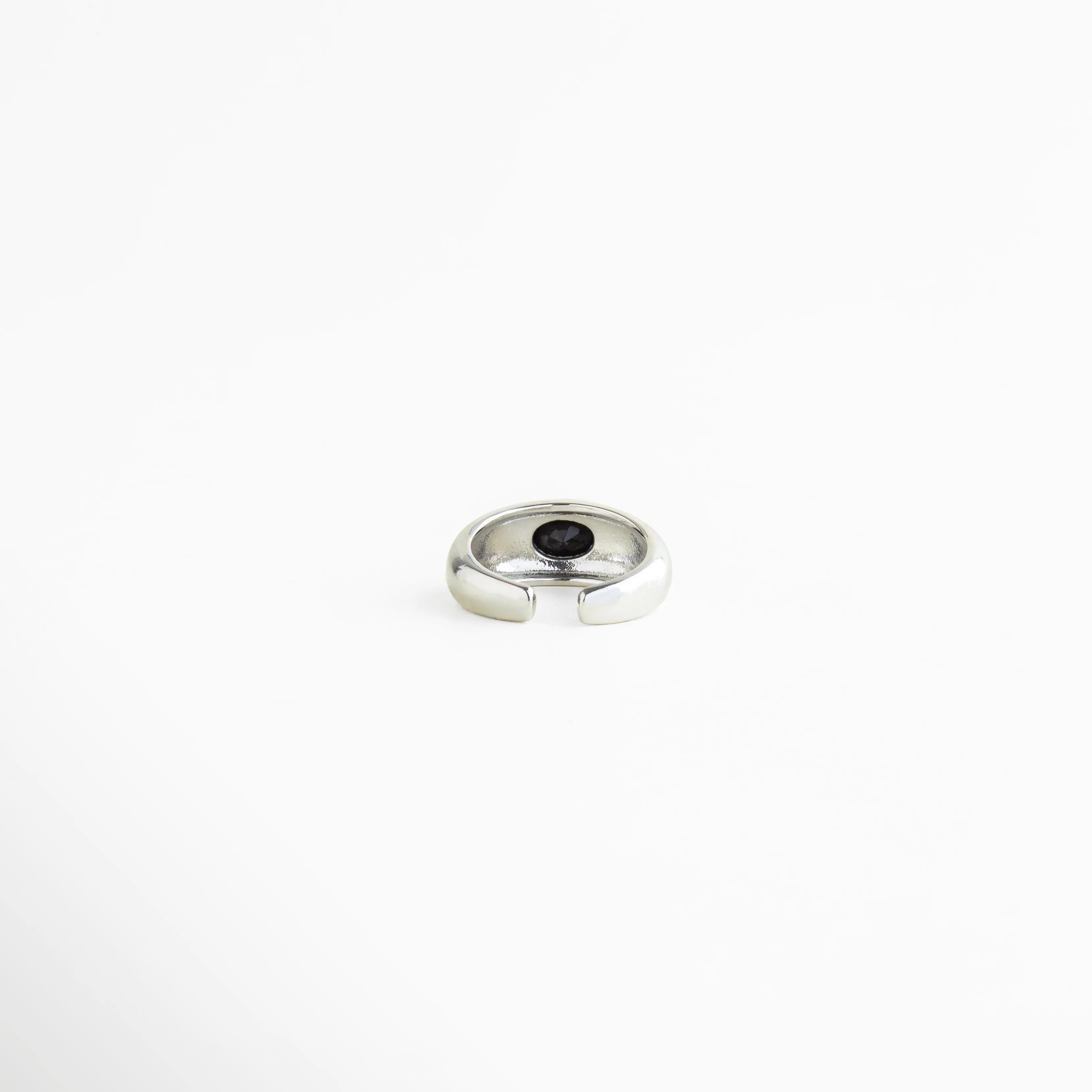 Vista superior del Anillo Callum con zirconia negra central y acabado brillante, Anillo elegante plateado visto desde arriba con piedra negra incrustada, Diseño superior del Anillo Callum con forma limpia y detalle sofisticado, Anillo ajustable con zirconia negra y estilo minimalista contemporáneo, Vista cenital de anillo brillante con acento oscuro y refinado.