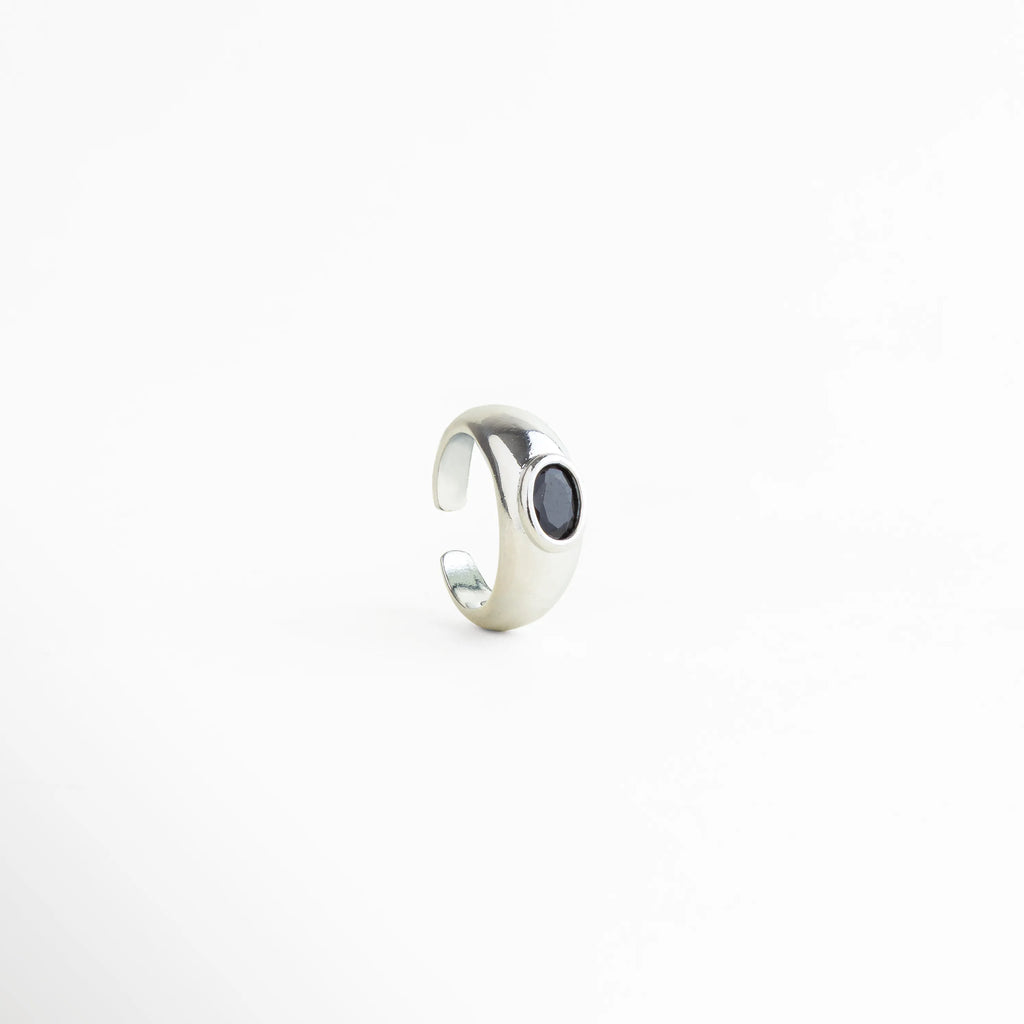 Vista lateral del Anillo Callum con diseño ajustable y zirconia negra elegante, Perfil del anillo plateado con acabado pulido y piedra negra sofisticada, Anillo abierto ajustable con silueta moderna y detalle de zirconia negra, Vista de perfil de anillo refinado con estilo contemporáneo y brillante, Detalle lateral del Anillo Callum con diseño limpio y toque misterioso.