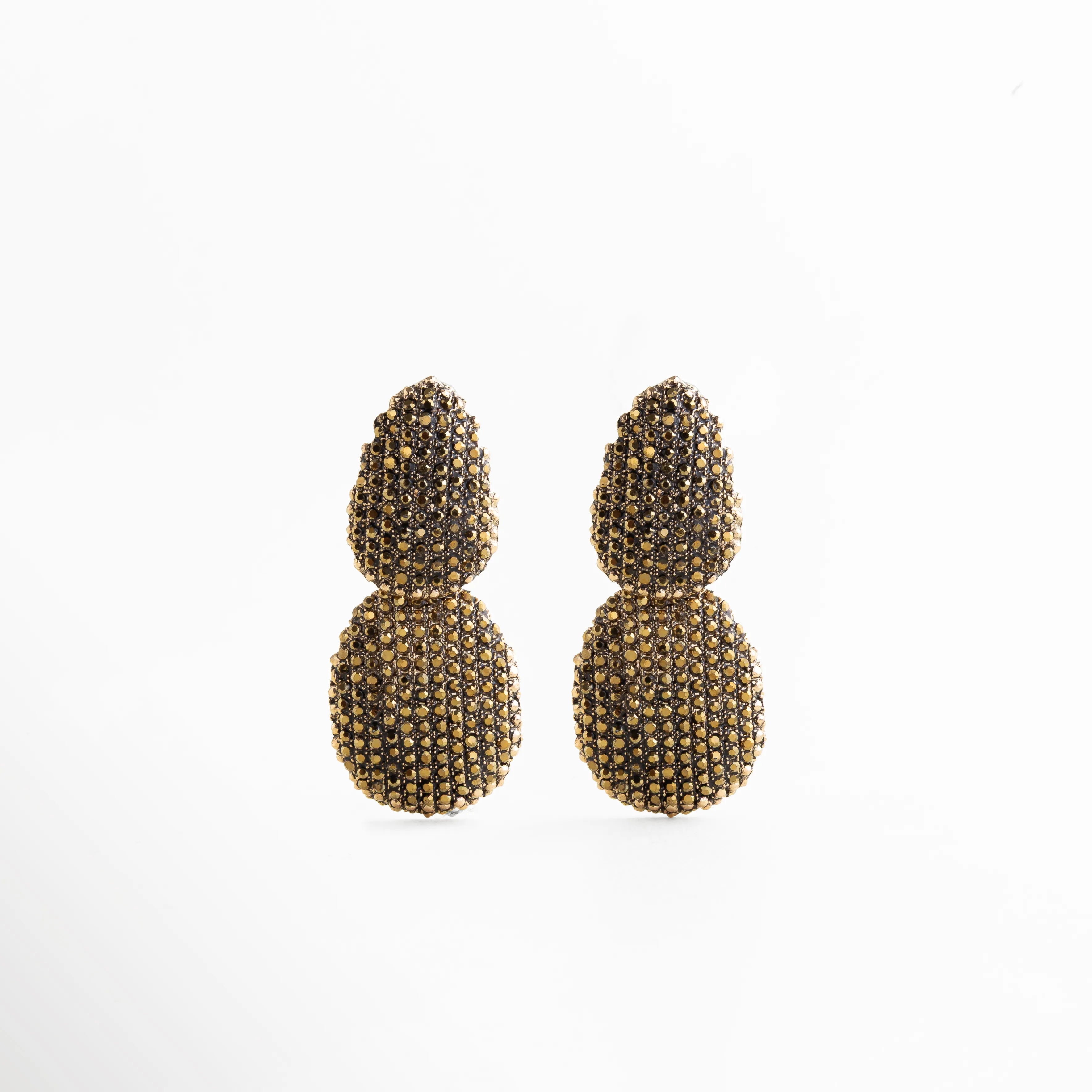 Aretes Golden Eira dorados con cristales pavé, diseño glam elegante y brillante, Aretes Golden Eira largos dorados con incrustaciones de cristales pavé, Aretes Golden Eira glam dorados con doble forma y acabado brillante, Aretes Golden Eira elegantes color oro con textura pavé y diseño voluminoso, Aretes Golden Eira de bisutería fina dorados con cristales pavé