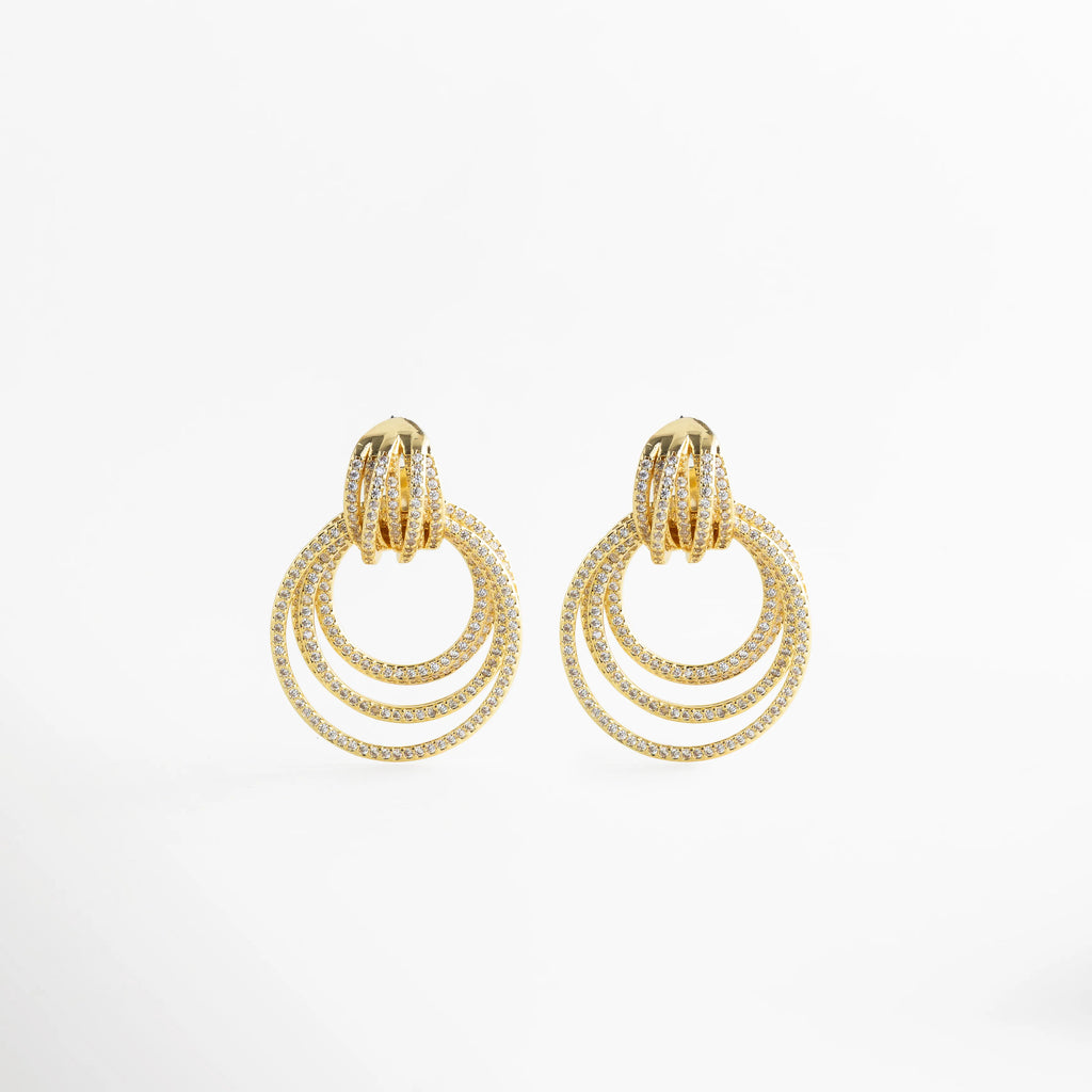 Aretes Elarisse dorados con zirconias, diseño de aros múltiples elegante y glam, Aretes Elarisse en oro 18K con zirconias brillantes y estilo sofisticado, Aretes Elarisse dorados con diseño circular en capas y acabado luminoso, Aretes Elarisse elegantes con zirconias y aros colgantes en tono oro, Aretes Elarisse de bisutería fina dorados con zirconias y diseño glam