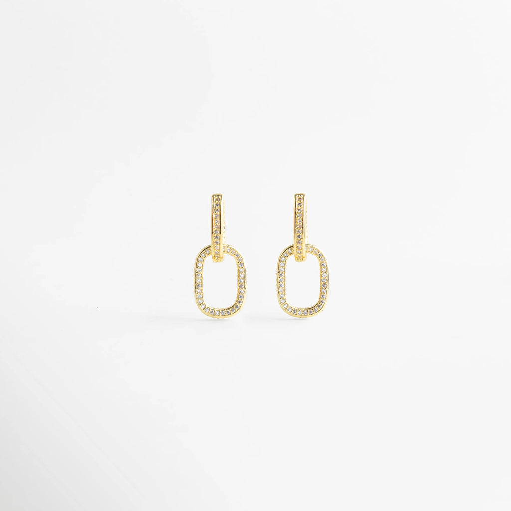 Pendientes de aro dorados con diseño de eslabón ovalado y circonitas incrustadas, Arracadas de oro con pavé de cristales brillantes en forma de eslabón doble, Aretes colgantes dorados elegantes con detalles de piedras brillantes sobre fondo blanco, Pendientes de eslabón bañados en oro con microcirconitas para look de fiesta, Joyería fina: pendientes ovalados de oro con cristales pequeños estilo minimalista.