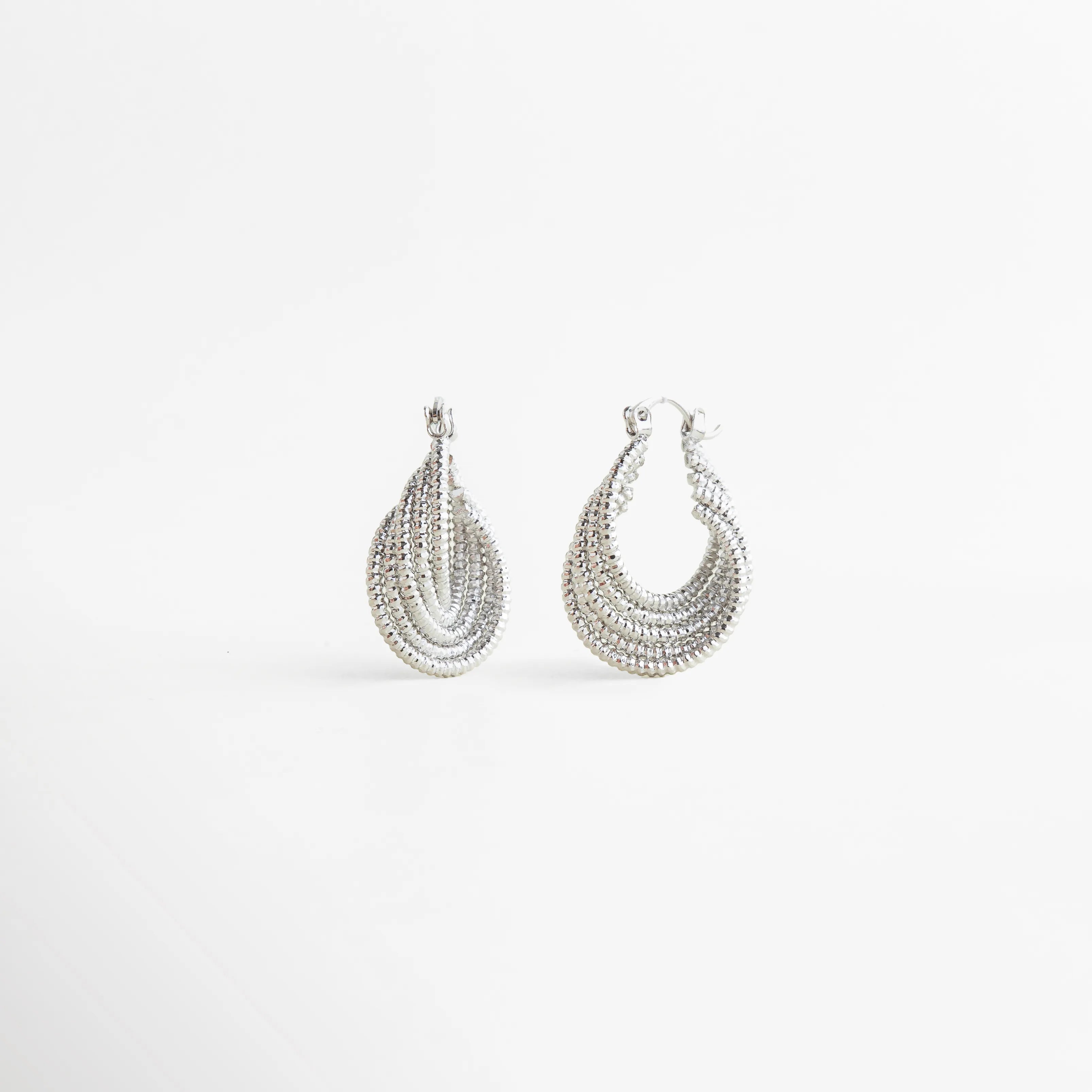 Aretes Amarielle plateados con diseño geométrico y acabado brillante elegante, Aretes Amarielle en tono plata con forma curva y estilo sofisticado moderno, Aretes Amarielle plateados con diseño en capas y acabado luminoso, Aretes Amarielle elegantes con forma ovalada y estilo minimalista moderno, Aretes Amarielle de bisutería plateados con diseño geométrico sofisticado
