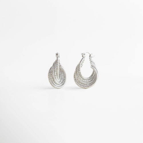Aretes Amarielle plateados con diseño geométrico y acabado brillante elegante, Aretes Amarielle en tono plata con forma curva y estilo sofisticado moderno, Aretes Amarielle plateados con diseño en capas y acabado luminoso, Aretes Amarielle elegantes con forma ovalada y estilo minimalista moderno, Aretes Amarielle de bisutería plateados con diseño geométrico sofisticado