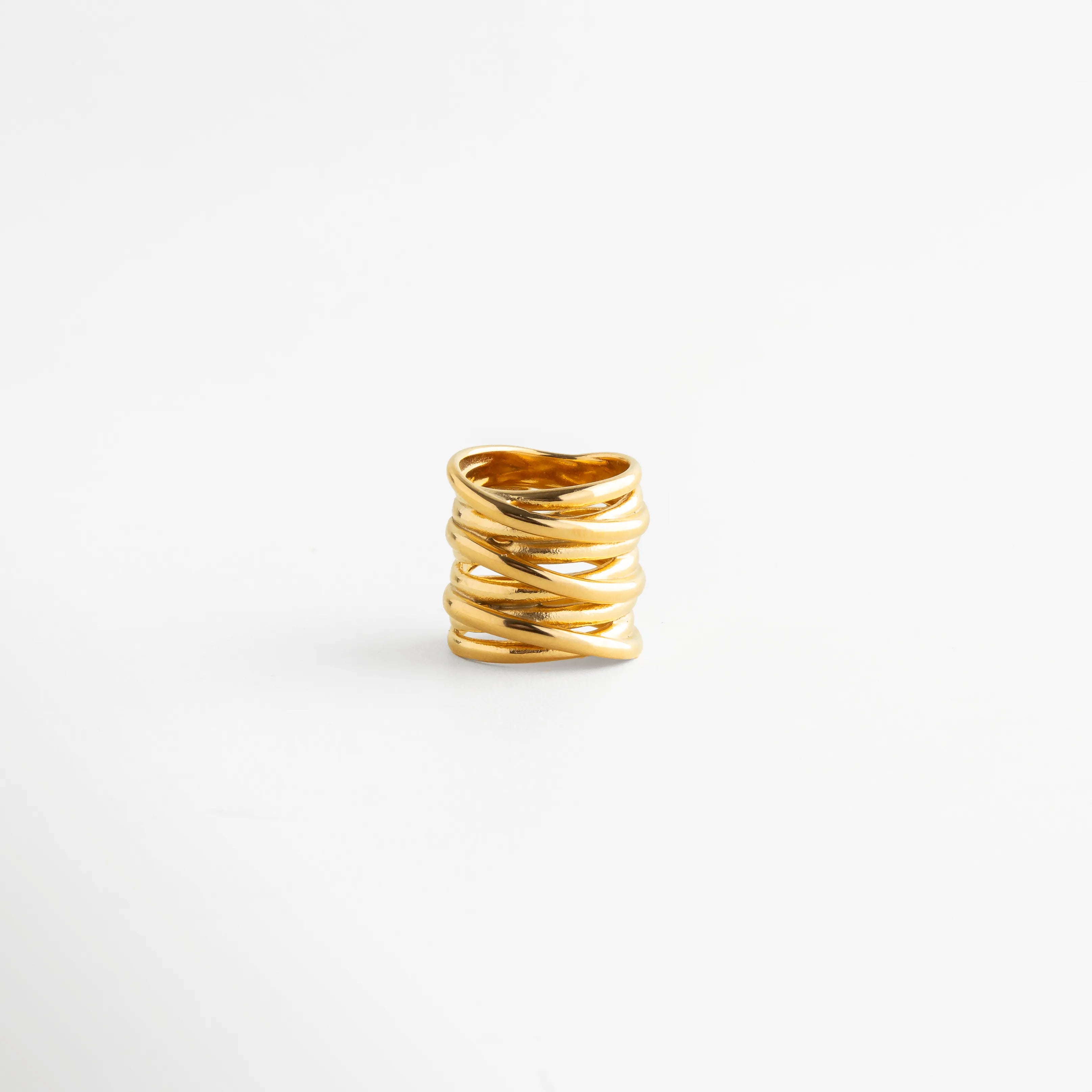 Vista frontal del Anillo Halo con diseño entrelazado y acabado dorado refinado, Anillo dorado de estilo moderno con estructura amplia y elegante, Diseño de anillo ancho con líneas cruzadas y apariencia sofisticada, Anillo Halo en vista completa con estilo minimalista y contemporáneo, Anillo de inspiración nórdica y vintage con acabado brillante en oro.