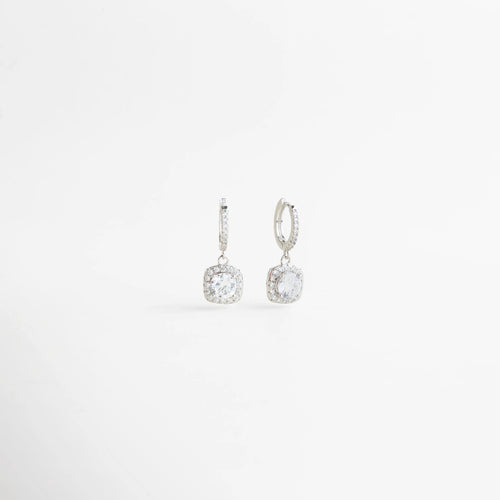 Aretes de zirconia en vista diagonal con diseño colgante y acabado elegante en plata, Vista lateral de aretes femeninos con aro pequeño y zirconia brillante colgante, Aretes delicados de Plata Ley 925 mostrados en ángulo para destacar su brillo y forma, Diseño sofisticado de aretes colgantes con zirconia redonda y acabado refinado, Aretes elegantes para mujer con caída sutil y piedra brillante en vista diagonal.