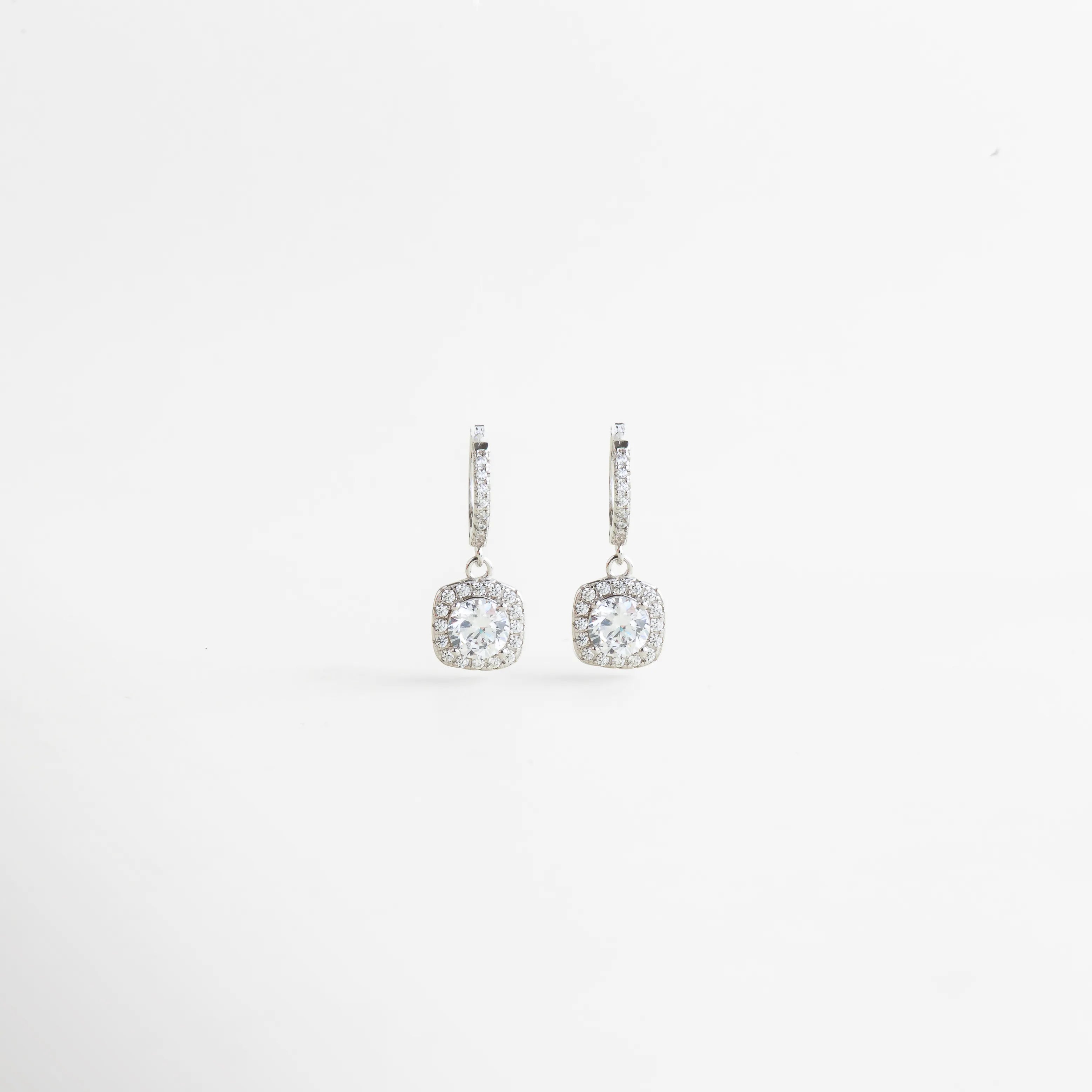 Aretes colgantes de Plata Ley 925 con zirconia brillante y diseño elegante para mujer, Vista frontal de aretes delicados con zirconia redonda y acabado sofisticado en plata, Par de aretes femeninos con zirconia luminosa y estilo refinado en Plata Ley 925, Aretes elegantes con detalle colgante y zirconia brillante, ideales para ocasiones especiales, Aretes de mujer con diseño delicado, brillo sutil y acabado en Plata Ley 925.