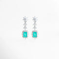 Aretes largos Cordelia en acabado de plata de rodio con gema central color turquesa y halo de circonias brillantes, Pendientes de gala con piedra rectangular aguamarina y diseño de hojas de cristal en cascada, Vista frontal de aretes elegantes de 5 cm de largo con circonias blancas y centro color turquesa intenso, Joyería de lujo: aretes con recubrimiento de rodio y piedras preciosas de laboratorio en tono aguamarina, Par de aretes Cordelia Turquesa resaltando el corte esmeralda de la gema central y el 
