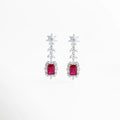 Aretes largos en acabado de plata de rodio con gema central roja y halo de circonias brillantes, Pendientes de gala con piedra roja rectangular y diseño de hojas de cristal en cascada, Vista frontal de aretes elegantes de 5 cm de largo con circonias blancas y centro color rubí, Joyería de lujo: aretes con recubrimiento de rodio y piedras preciosas de imitación en color rojo, Par de aretes Rojos resaltando el corte esmeralda de la gema central y el brillo del pavé.