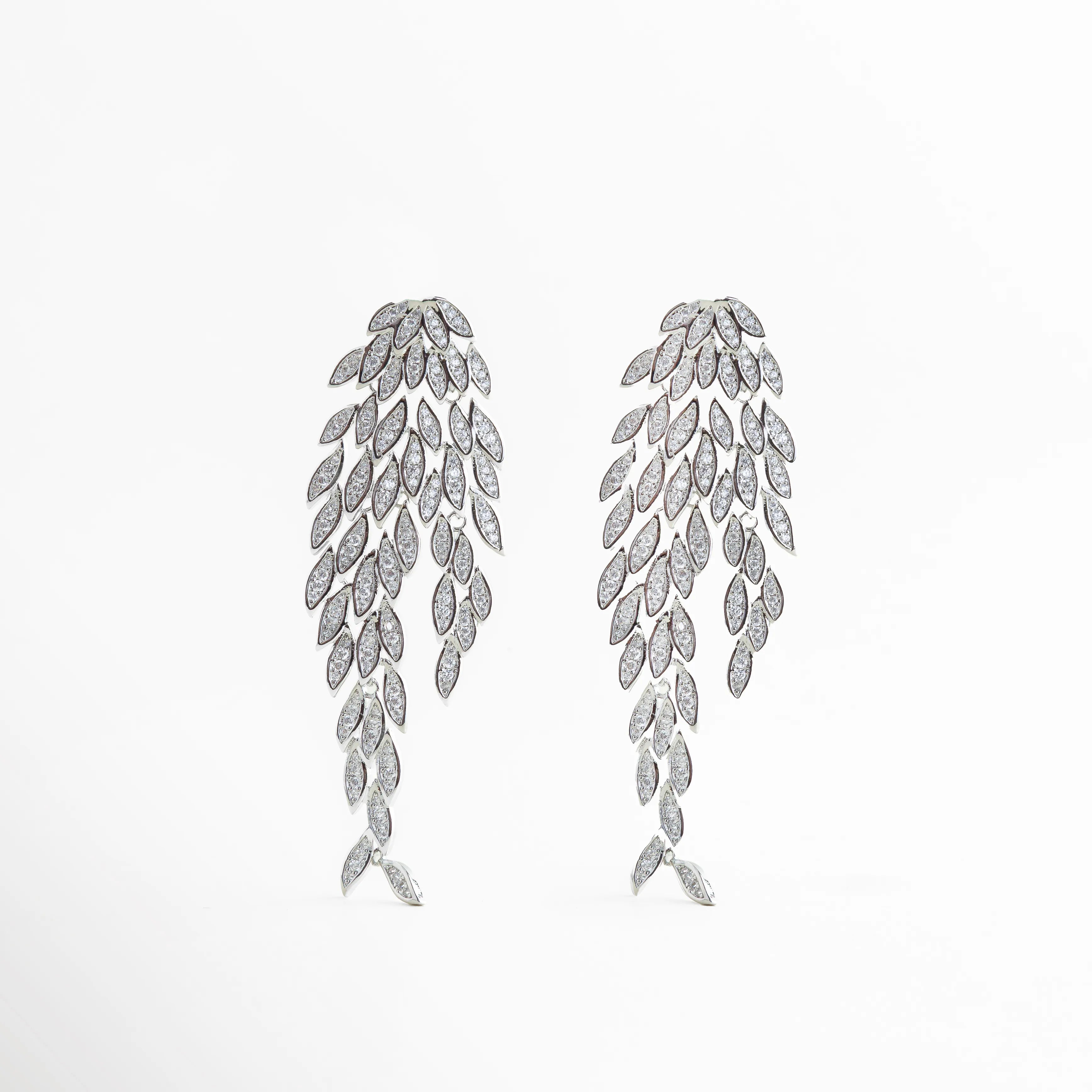 Aretes largos de cobre con baño de plata esterlina y diseño de hojas en cascada con circonias, Pendientes de gala con múltiples incrustaciones de zirconia y acabado brillante en plata, Vista frontal de aretes de 7.5 cm de largo con diseño botánico de lujo y poste de plata ley 925, Joyería de declaración: aretes plateados con racimos de circonias de corte marquesa, Par de aretes elegantes con estructura articulada de hojas brillantes sobre fondo blanco.