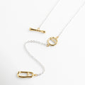 Acento circular dorado con diseño calado en cadena delgada de oro blanco 18K, Detalle de dije pequeño redondo enchapado en oro sobre eslabones platinados, Vista de cerca de elemento decorativo circular en collar de dos tonos plata y oro, Componente geométrico dorado incrustado en cadena de collar minimalista bi-color, Detalle artístico de placa circular dorada en collar de acabado platinado elegante.