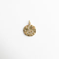 Charm dorado circular con diseño de serpiente decorada con zirconias y pequeñas estrellas en relieve, símbolo de transformación y poder, ideal para quienes buscan un accesorio con energía mística y elegante