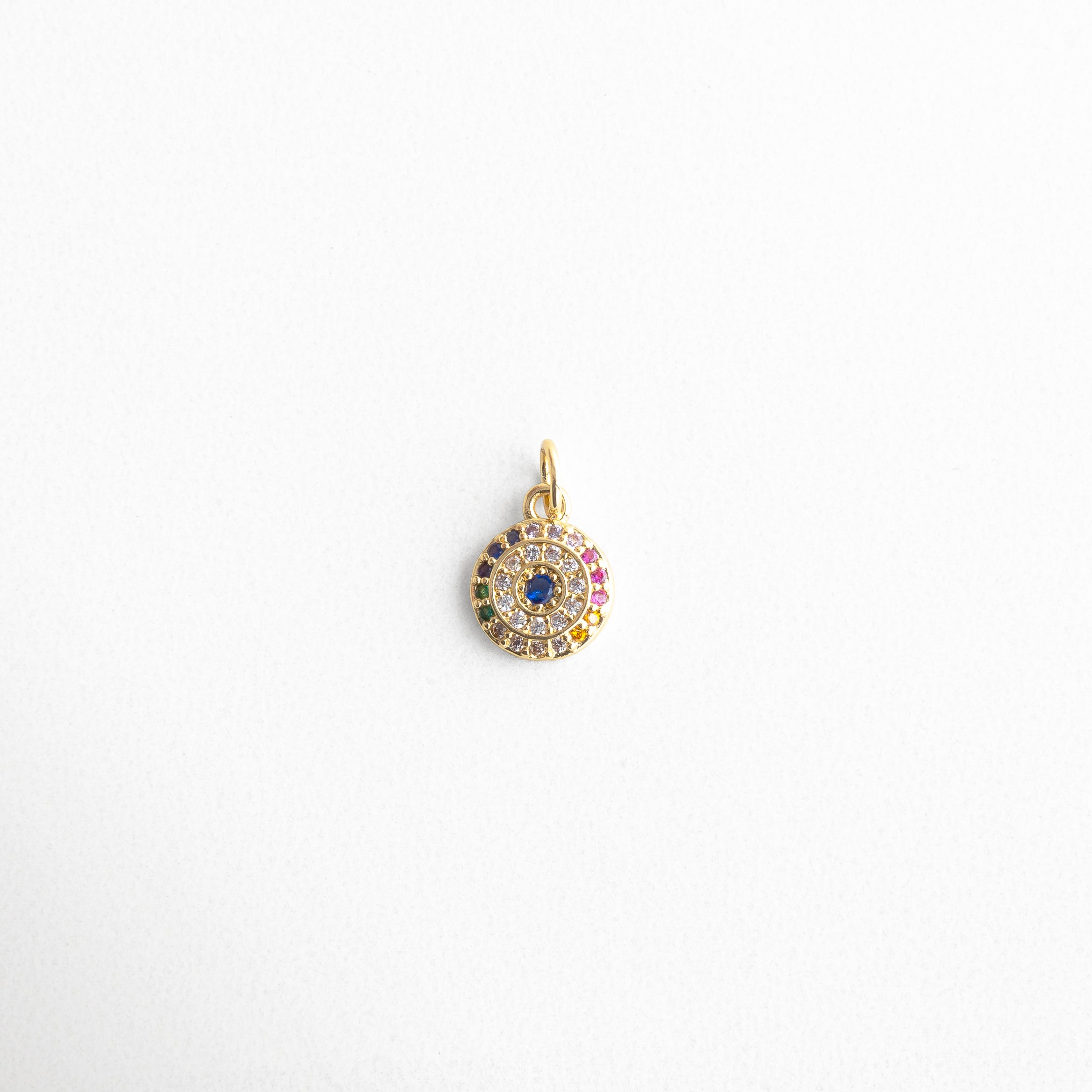 Charm dorado circular con zirconias multicolor en forma de ojo, diseño brillante y protector, símbolo del ojo turco moderno, ideal para atraer energía positiva y alejar las malas vibras con estilo