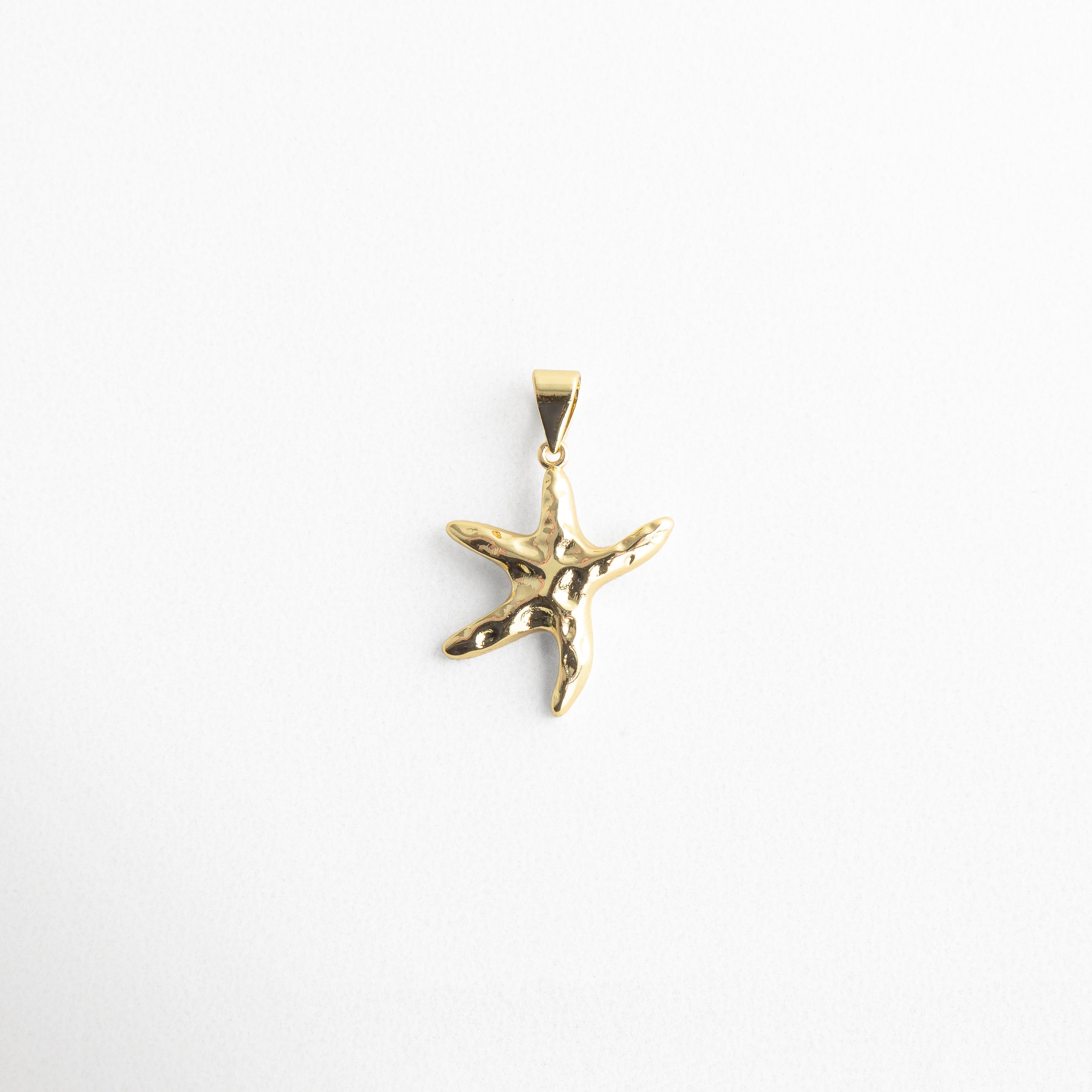 Dije dorado en forma de estrella de mar, diseño veraniego y elegante, Charm dorado con textura orgánica inspirado en el mar, ideal para combinar, Colgante dorado de estrella de mar con acabado brillante y diseño moderno.