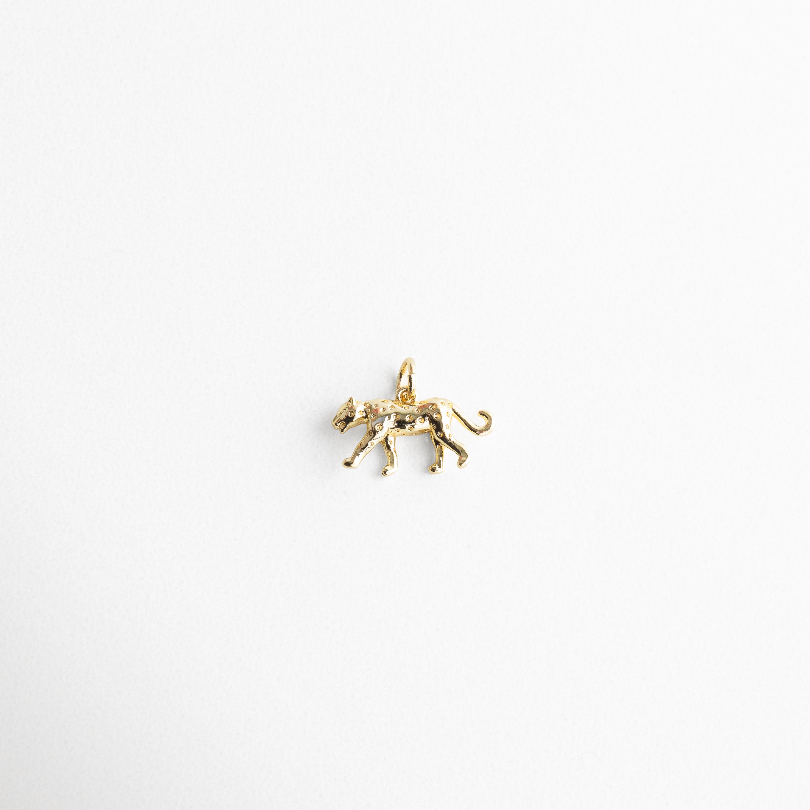 Charm dorado en forma de jaguar con incrustaciones brillantes, diseño elegante y con fuerza, símbolo de poder y confianza, ideal para quienes buscan un toque salvaje y sofisticado en su estilo