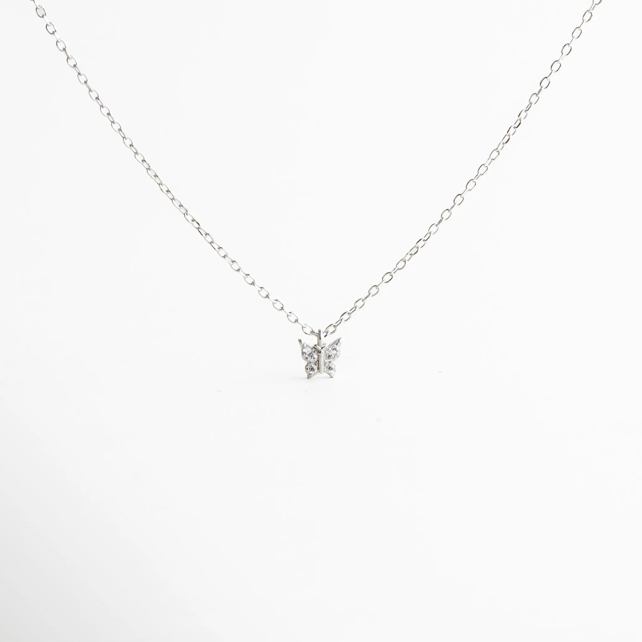 Collar plateado con cadena fina y mariposa central con destellos de zirconias, diseño sutil y elegante para uso diario o en capas.