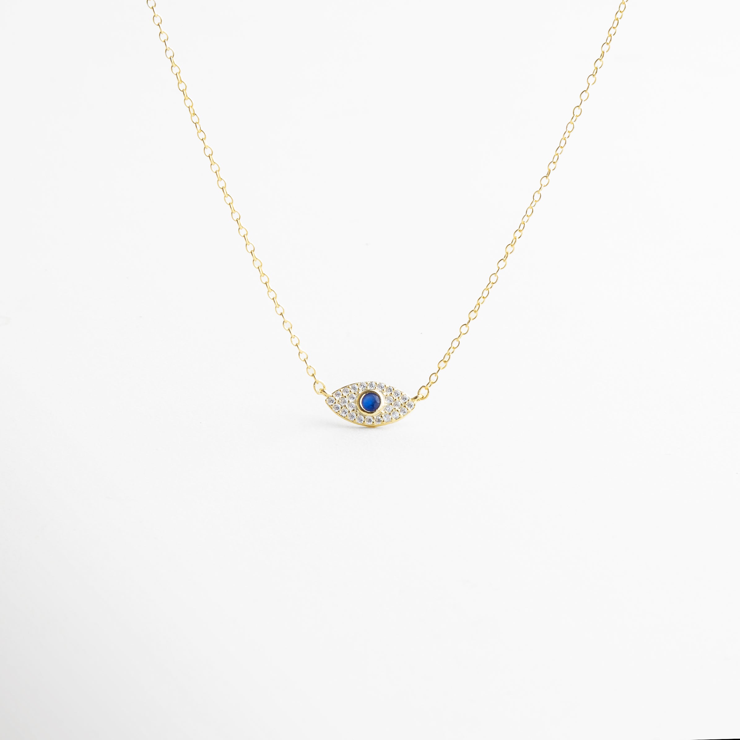 collar dorado con ojo turco de zirconias, joya protectora dorada con dije místico, collar amuleto de protección en oro 18K, collar elegante con ojo turco y brillo de zirconias, diseño minimalista con símbolo de buena fortuna