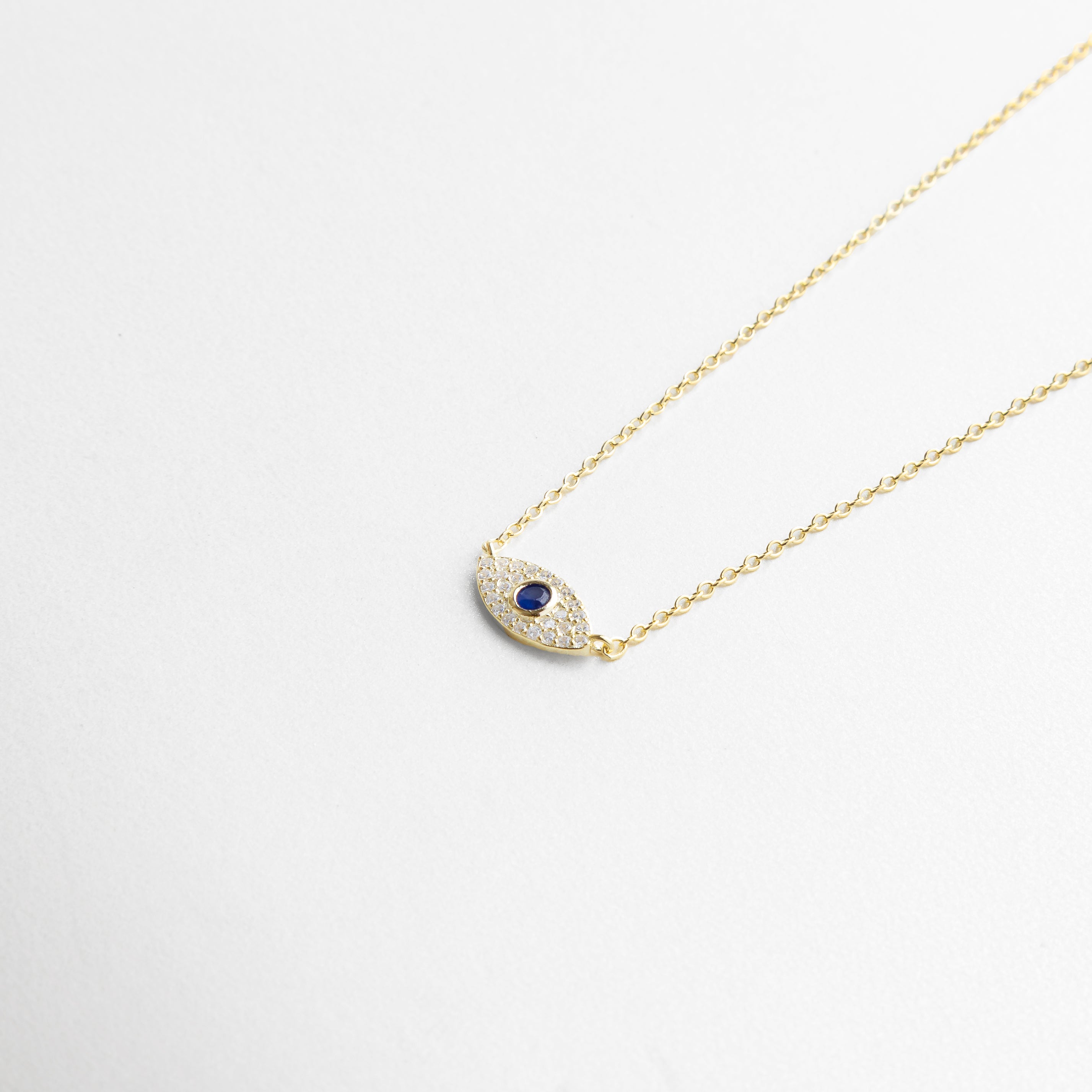 incrustaciones de zirconias en collar dorado, dije de ojo turco dorado con detalles brillantes, acabado enchapado en oro 18K de alta calidad, engaste fino en collar con amuleto protector, textura pulida y destellos en el diseño