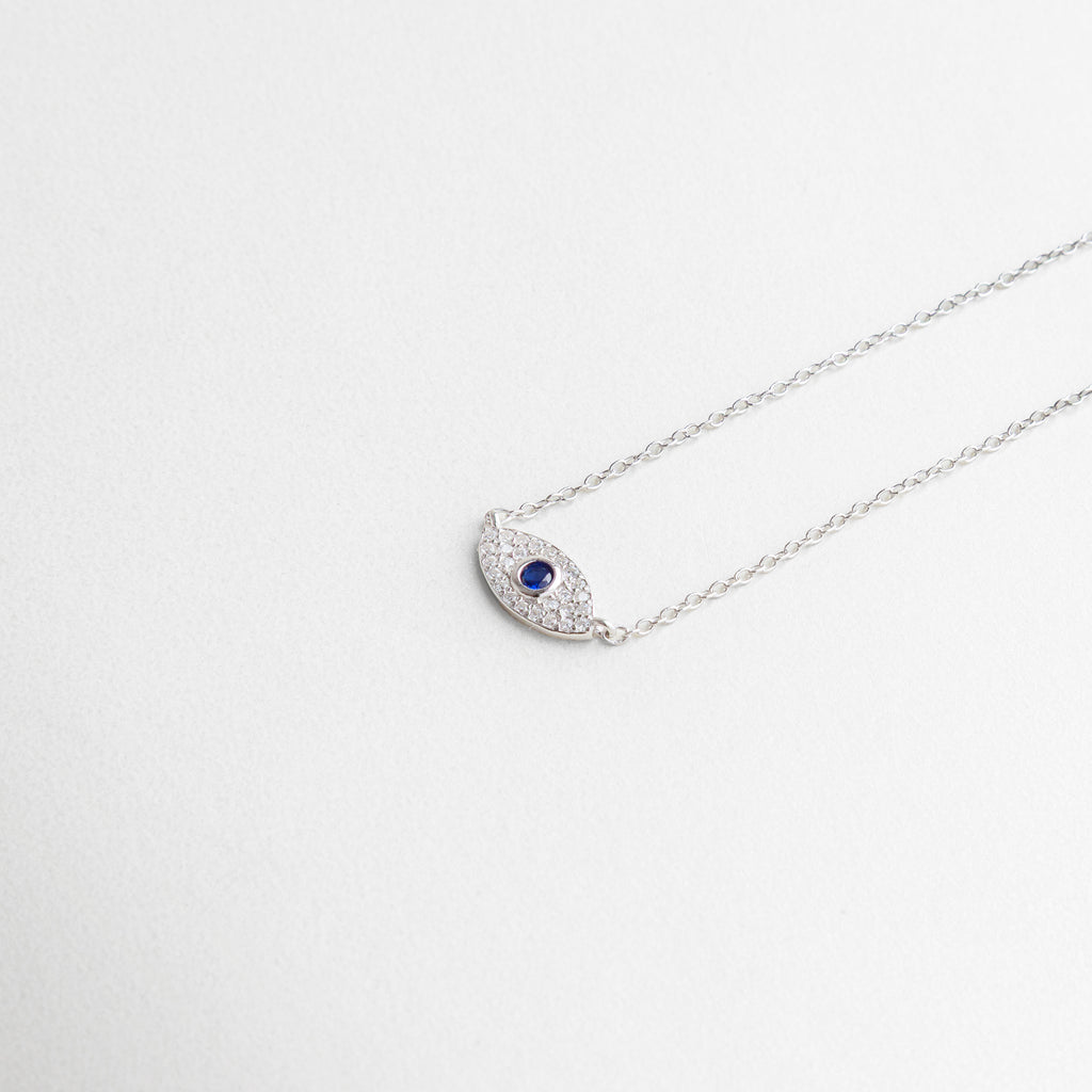 dije de ojo turco en plata ley 925, incrustaciones de zirconias brillantes, diseño delicado con acabado pulido, equilibrio entre misticismo y elegancia, detalle central que atrae miradas