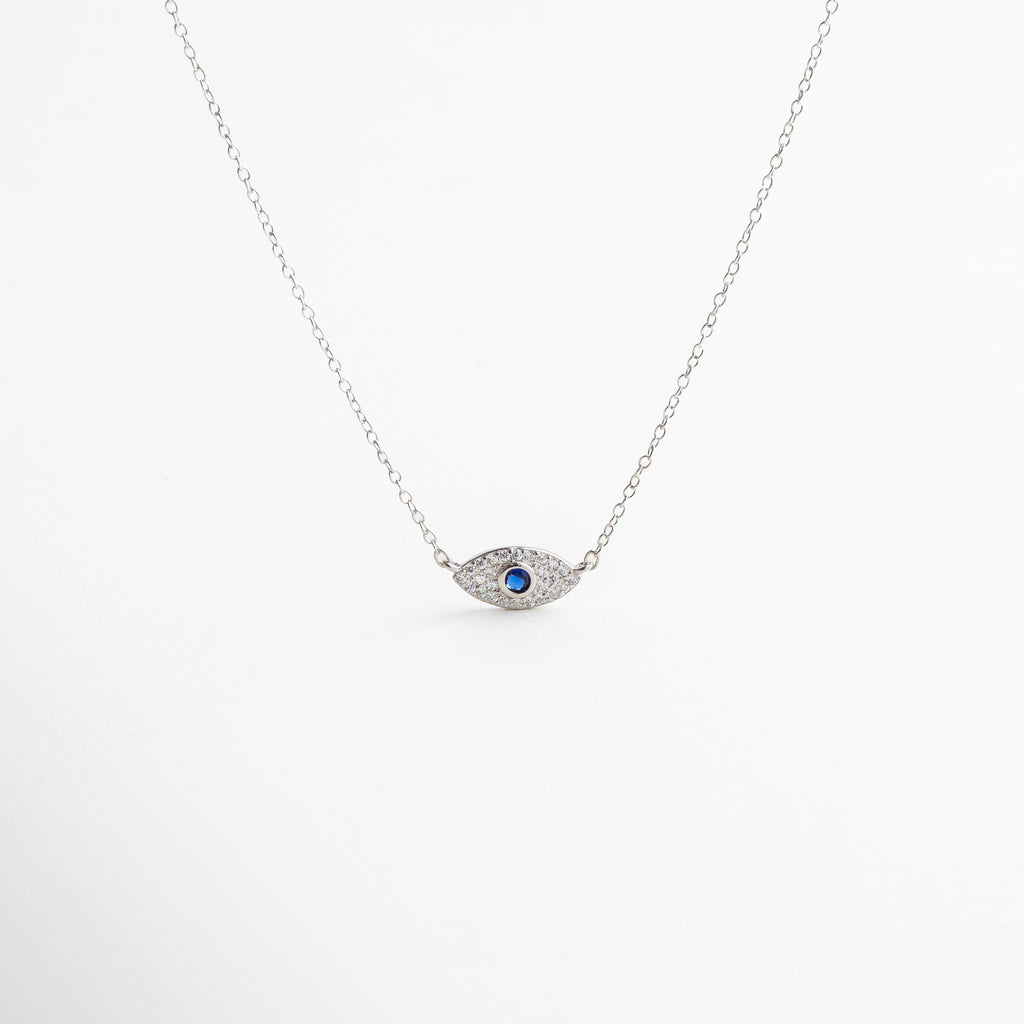 collar plateado con dije de ojo turco, diseño moderno y simbólico, acabado en oro blanco 18K con zirconias, estilo protector y elegante, pieza versátil para looks diarios o de noche