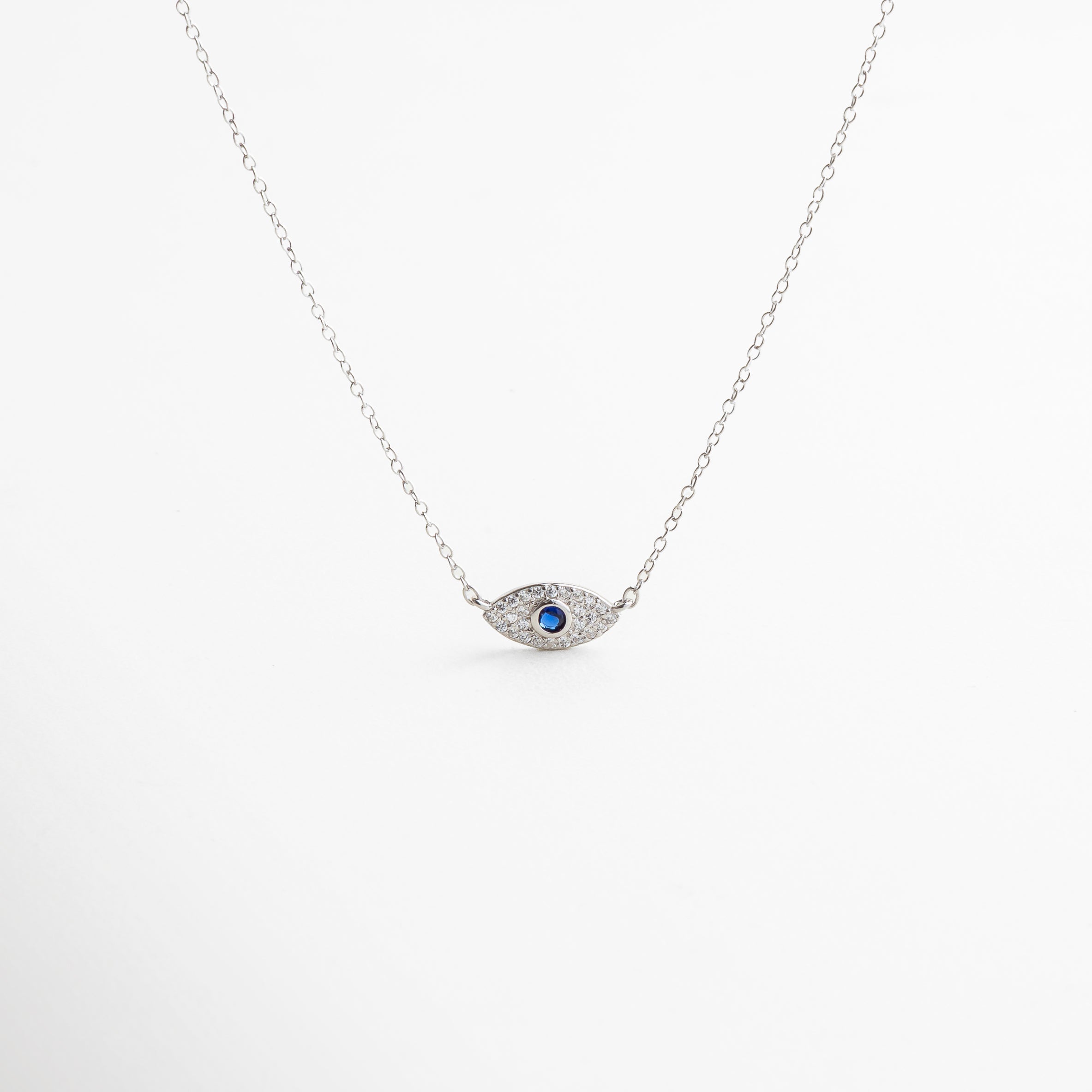 collar plateado con dije de ojo turco, diseño moderno y simbólico, acabado en oro blanco 18K con zirconias, estilo protector y elegante, pieza versátil para looks diarios o de noche