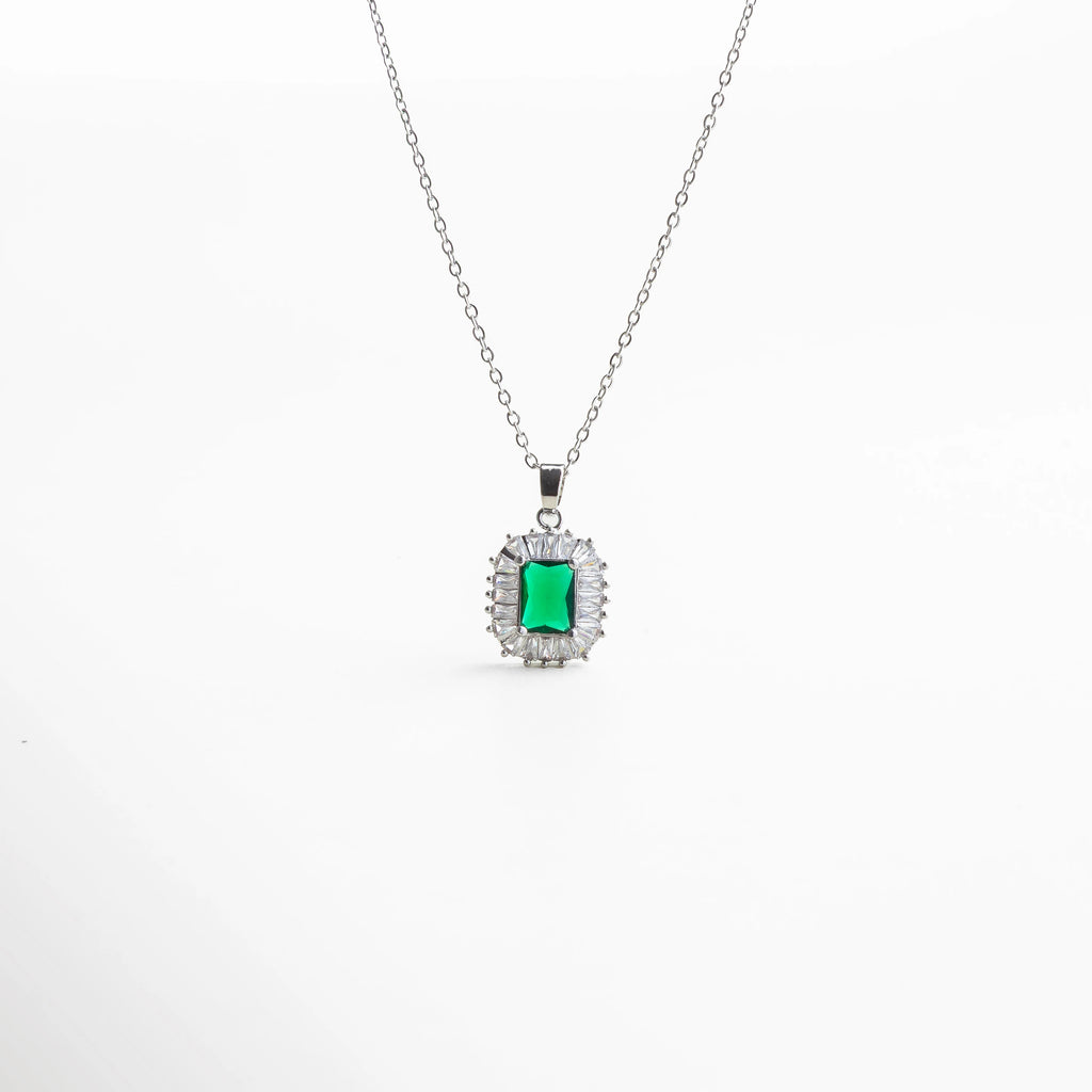 Collar plateado con dije de piedra verde rectangular estilo esmeralda, rodeado de destellos claros, diseño clásico ideal para ocasiones especiales.