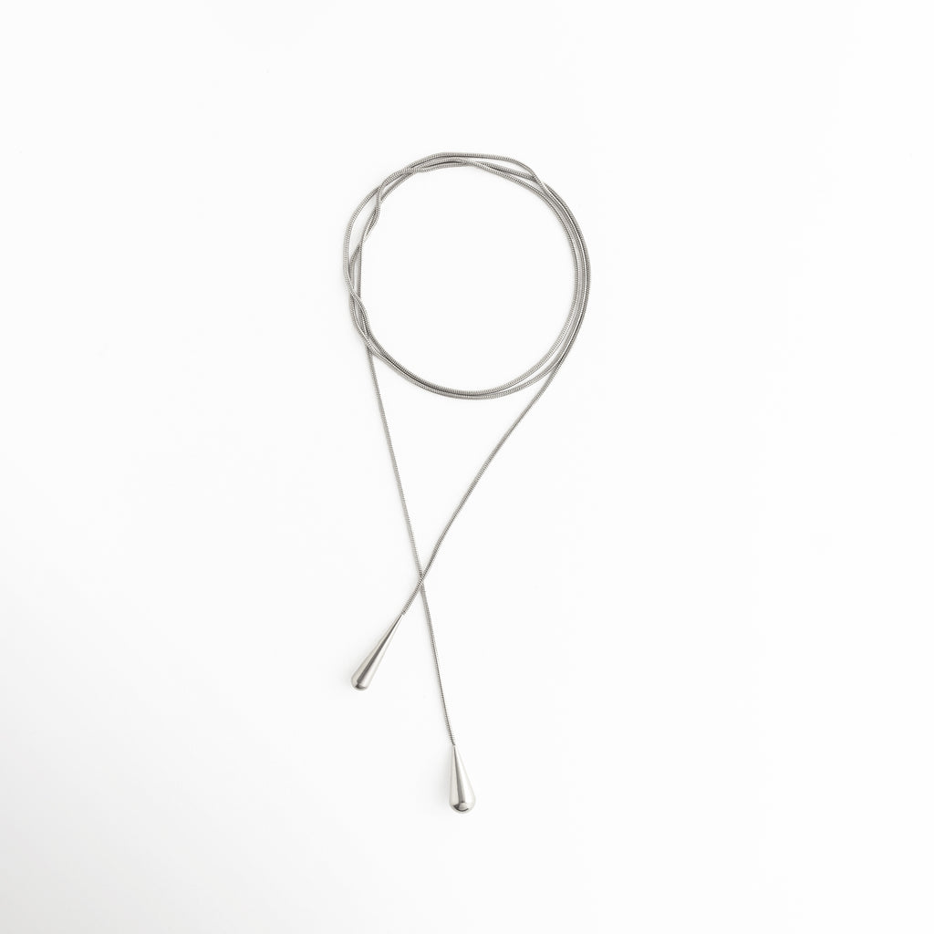 collar lariat largo vista completa, collar largo minimalista joyería moderna, collar elegante estilo lariat mujer, joyería fina collar largo contemporáneo, collar alargado diseño limpio y fluido