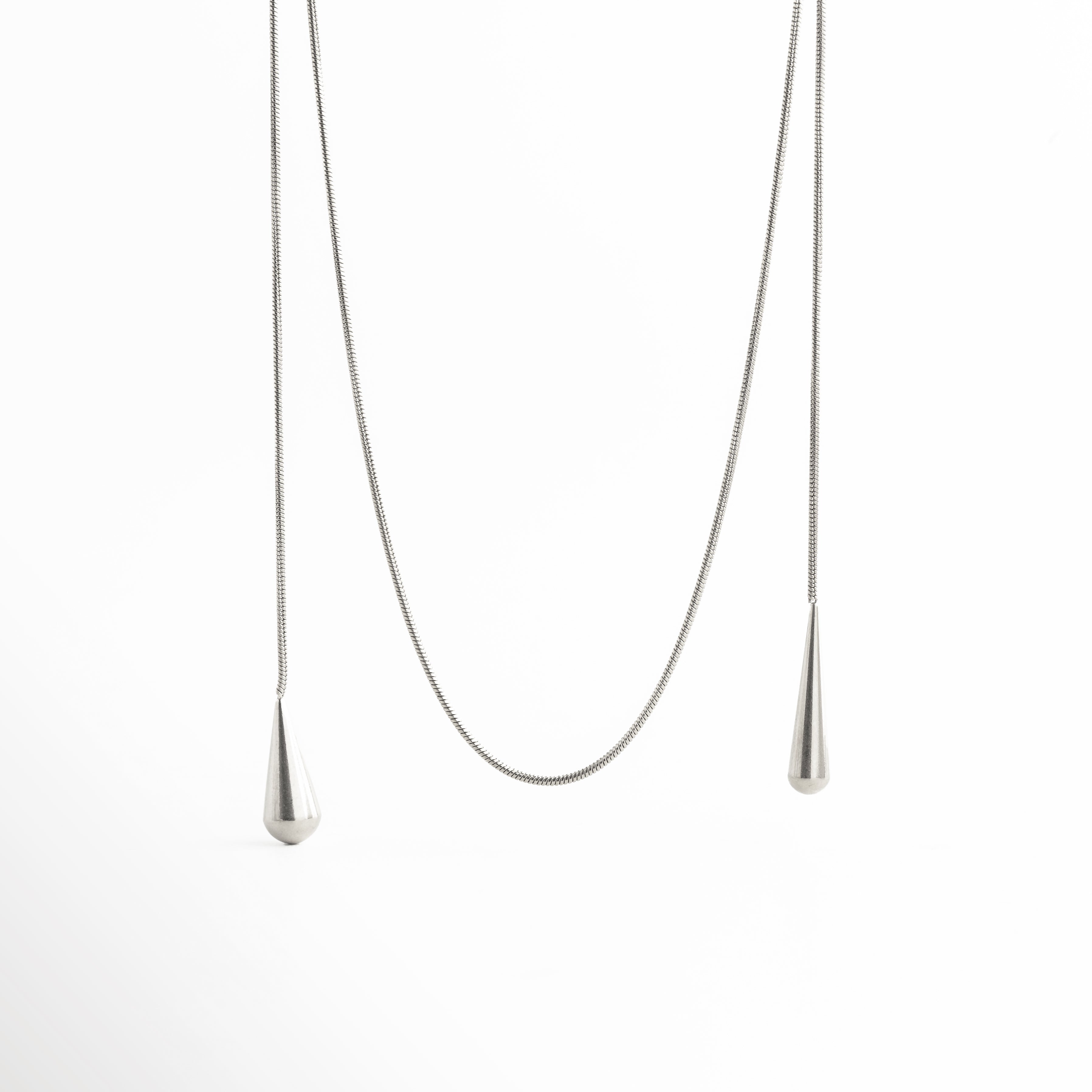 detalle de cadena en collar lariat, collar largo con cadena fina elegante, textura de cadena joyería minimalista, collar estilo lariat acabado sofisticado, joya moderna detalle de cadena