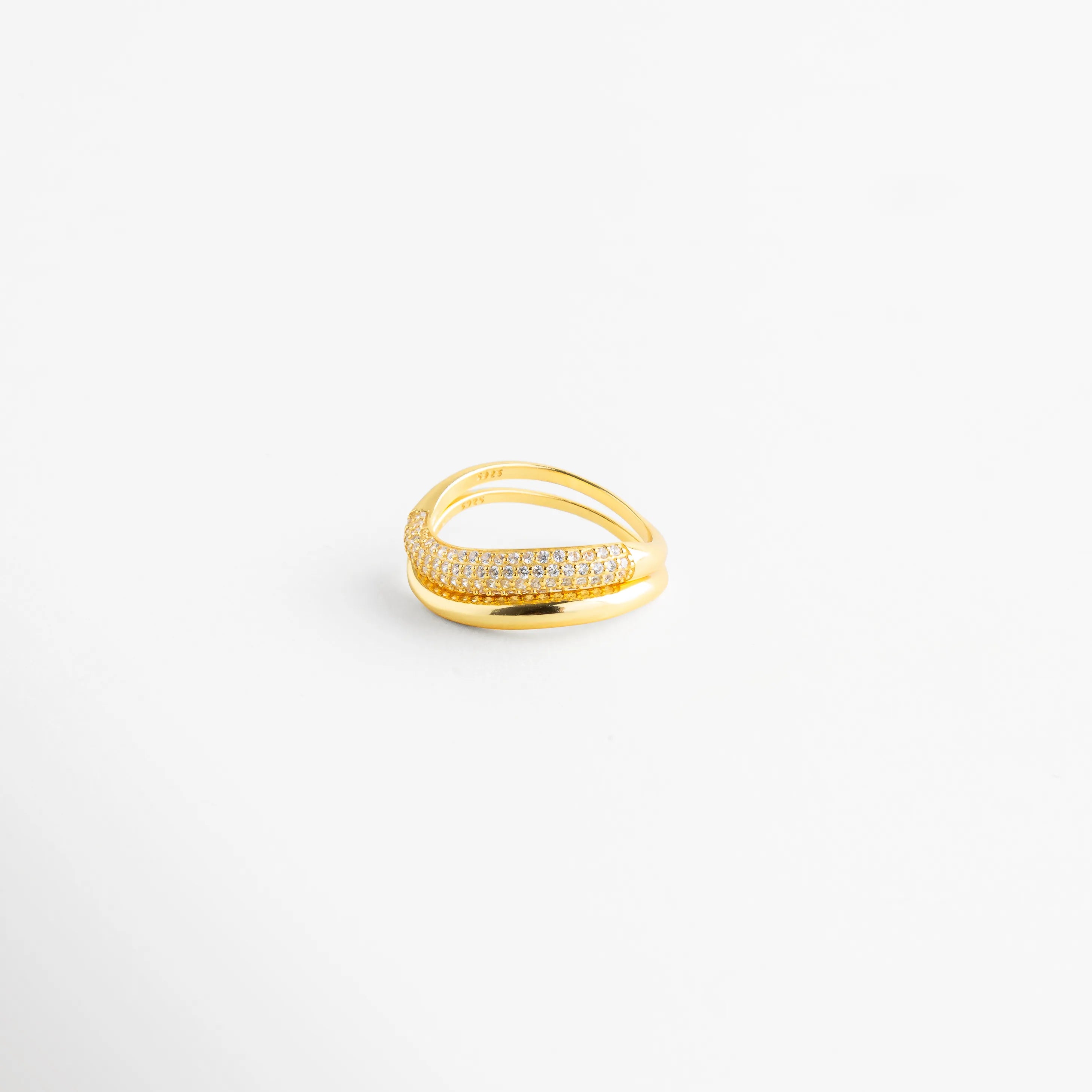 Vista desde arriba de anillo de plata con bandas cruzadas y brillo de diamantes AB, Detalle del engaste de los Diamantes AB en anillo de plata ley 925 dorada, Perspectiva superior de sortija elegante con juego de texturas lisa y brillante, Anillo de plata con recubrimiento enchapado visto desde un ángulo cenital, Diseño de anillo envolvente con micro-pavé de diamantes brillantes.