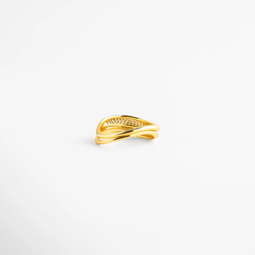 Vista en tres cuartos de anillo de plata 925 con destellos de diamantes AB, Anillo dorado de bandas asimétricas con cristales tornasolados para mujer, Detalle frontal de sortija de plata con acabado pulido espejo y pedrería, Anillo de doble banda entrelazada con baño de oro y piedras preciosas, Joyería fina de plata ley 925 con diseño de vanguardia y diamantes AB.