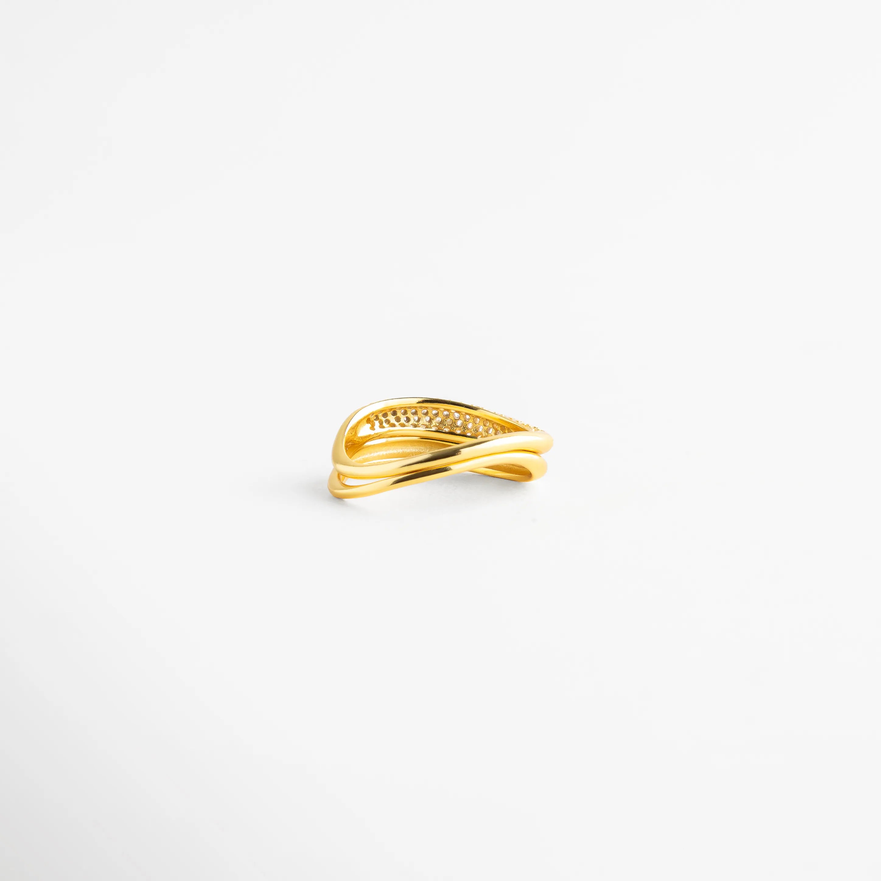 Vista en tres cuartos de anillo de plata 925 con destellos de diamantes AB, Anillo dorado de bandas asimétricas con cristales tornasolados para mujer, Detalle frontal de sortija de plata con acabado pulido espejo y pedrería, Anillo de doble banda entrelazada con baño de oro y piedras preciosas, Joyería fina de plata ley 925 con diseño de vanguardia y diamantes AB.