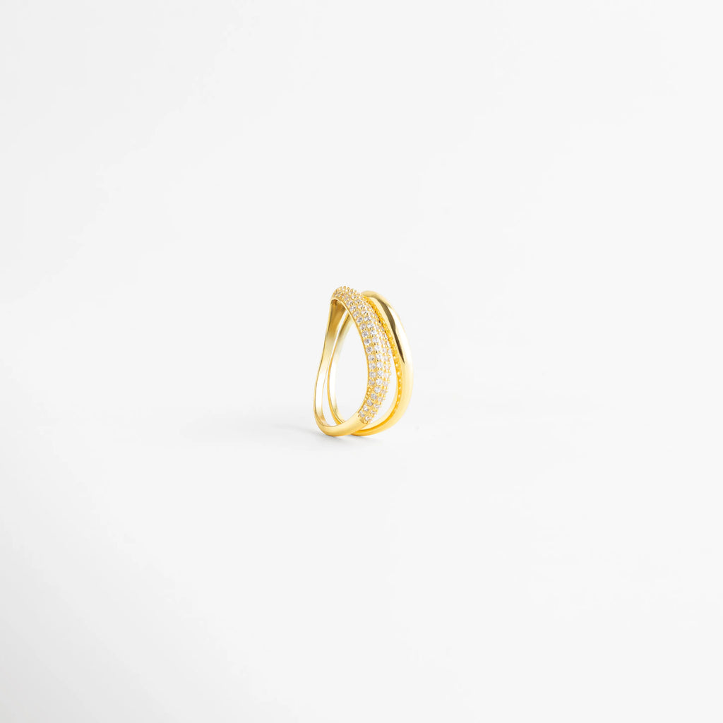 Vista lateral de anillo de plata 925 mostrando la curvatura y el diseño abierto, Perfil de anillo dorado con banda de diamantes AB y banda lisa pulida, Detalle constructivo de sortija de plata ley 925 con acabado de lujo, Estructura de anillo de doble hilo con incrustaciones frontales de diamantes, Perspectiva de perfil de anillo moderno con piedras preciosas artificiales.