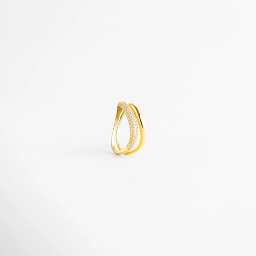 Vista lateral de anillo de plata 925 mostrando la curvatura y el diseño abierto, Perfil de anillo dorado con banda de diamantes AB y banda lisa pulida, Detalle constructivo de sortija de plata ley 925 con acabado de lujo, Estructura de anillo de doble hilo con incrustaciones frontales de diamantes, Perspectiva de perfil de anillo moderno con piedras preciosas artificiales.