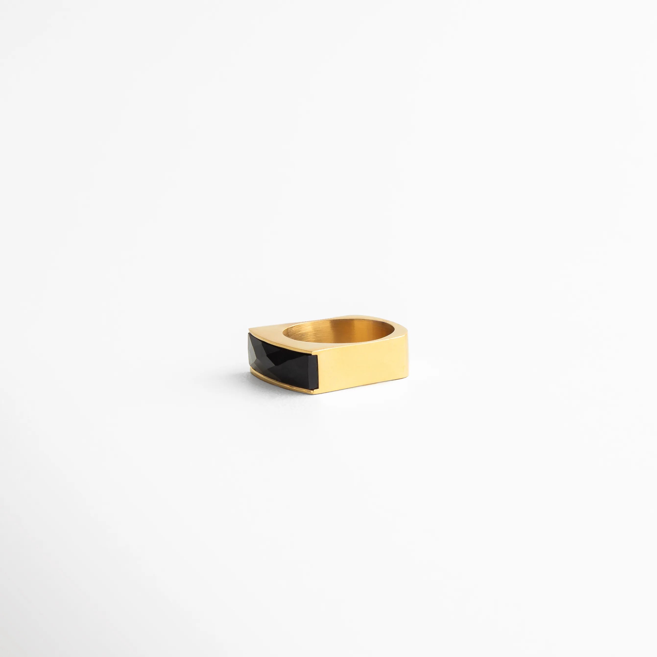 Vista lateral del anillo bicolor dorado y negro, diseño minimalista con líneas limpias y estilo elegante.