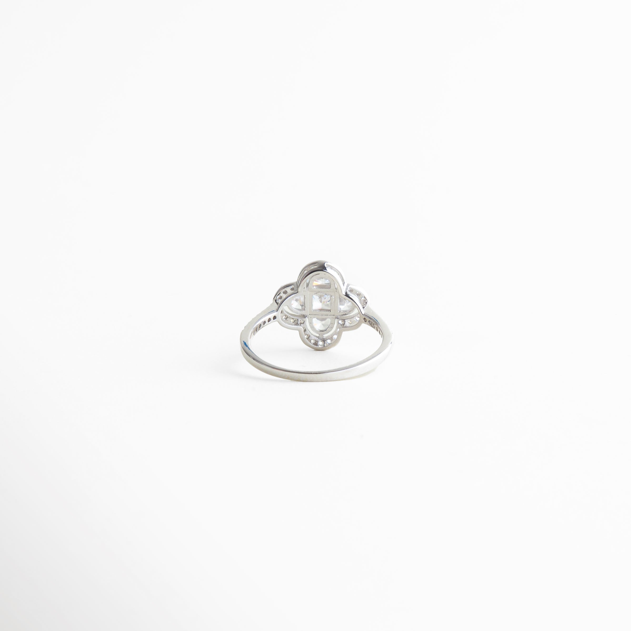 detalle cristalino en anillo trébol plateado, brillo sutil en anillo elegante femenino, acabado pulido en anillo trébol, diseño refinado de trébol cuatro hojas, anillo joyería fina detalle frontal