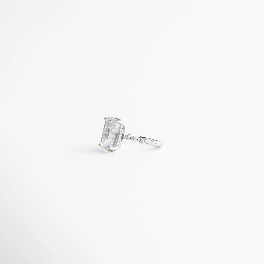 anillo plateado vista lateral con zirconias, detalle de aro con incrustaciones brillantes, anillo elegante con perfil delgado, joyería fina anillo lateral detallado, anillo moderno con acabado pulido, anillo plateado con montaje delicado