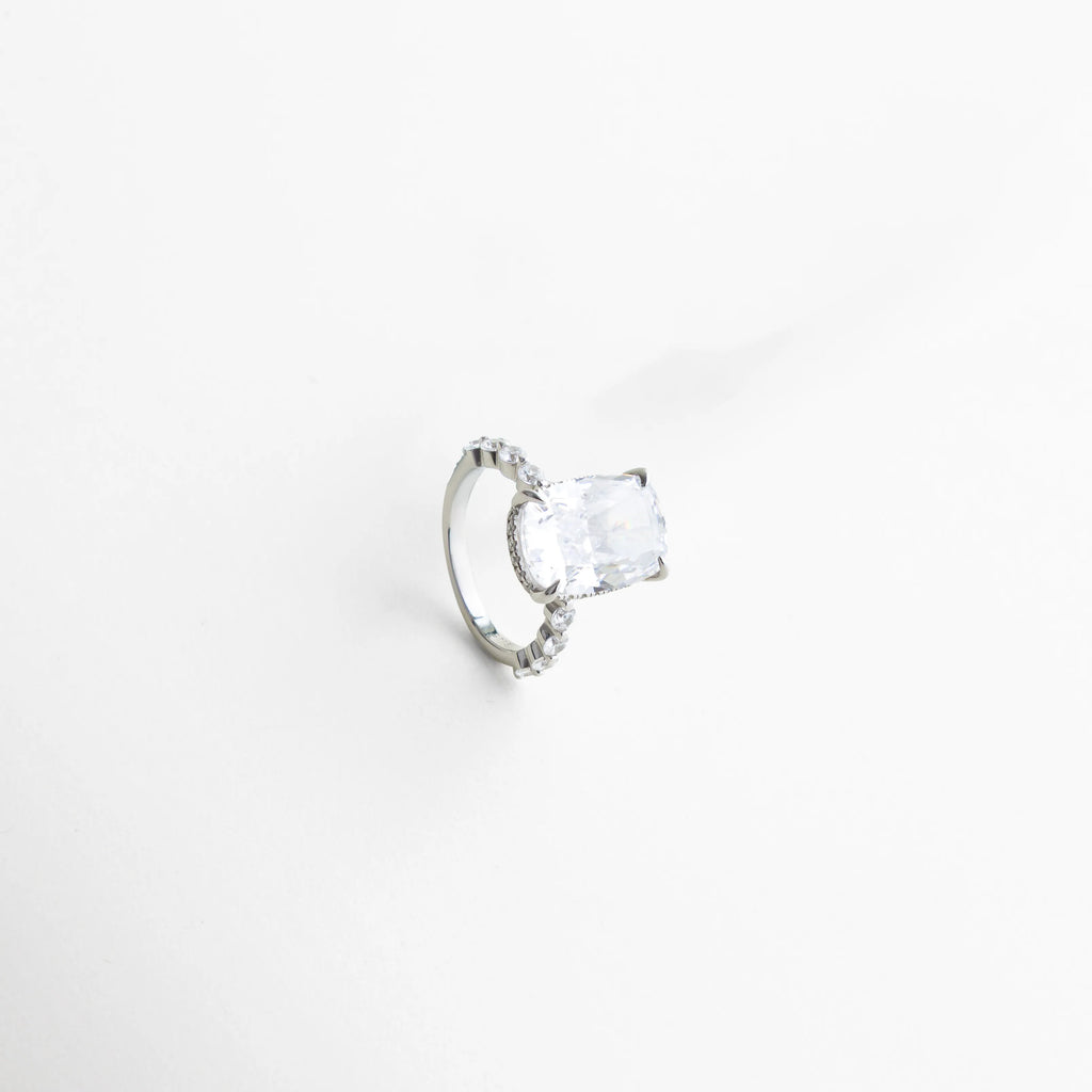 anillo plateado vista lateral derecha, detalle del engaste de la zirconia central, anillo con diseño fino y sofisticado, joyería elegante con zirconias laterales, anillo plateado de estilo contemporáneo, anillo femenino con acabado brillante