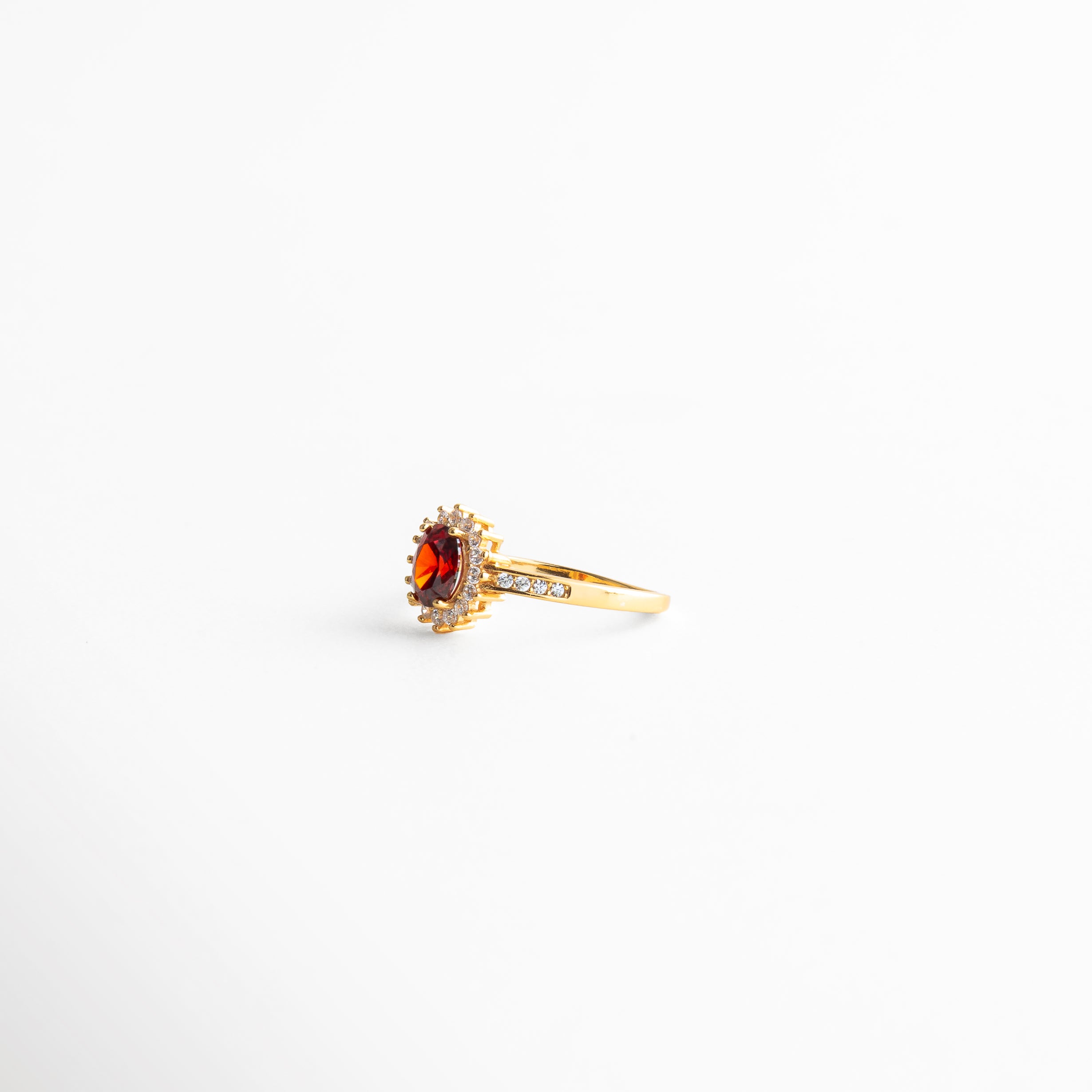 anillo dorado vista lateral con engaste elevado, perfil delgado de anillo con rubí central, estructura fina de anillo elegante, joyería dorada vista lateral minimalista, anillo femenino con diseño refinado