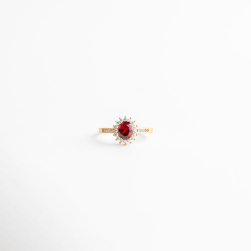 anillo dorado con rubí ovalado rodeado de zirconias, anillo delicado de joyería fina con piedra central, anillo elegante con halo de zirconias, joyería femenina anillo dorado sofisticado, anillo clásico moderno con diseño oval