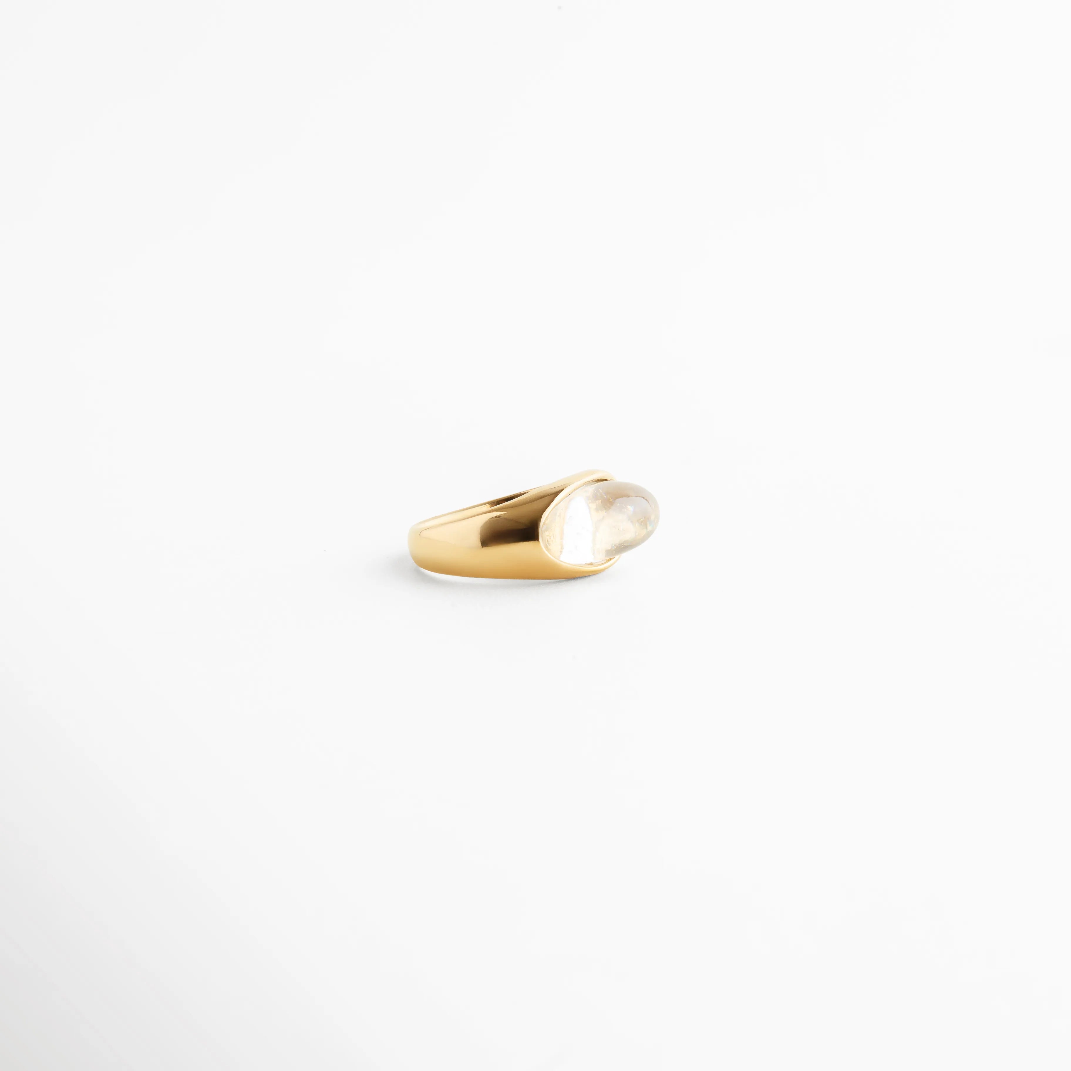 perfil de anillo dorado ovalado, anillo dorado vista lateral pulida, diseño de anillo dorado moderno, anillo dorado con volumen suave, anillo dorado acabado brillante, joyería dorada minimal