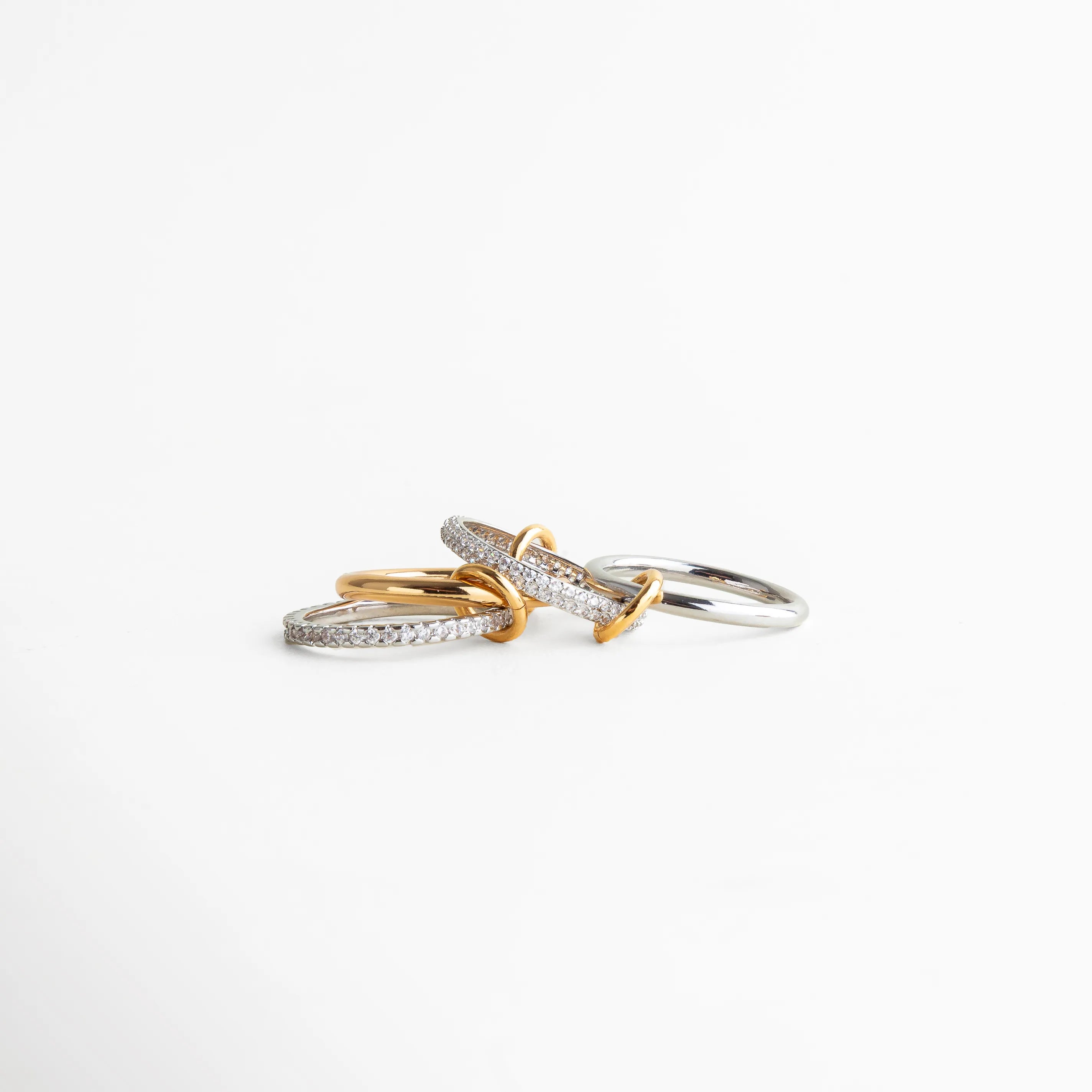Vista en ángulo del anillo dorado y plateado con aros cruzados, diseño elegante que aporta movimiento y profundidad visual.