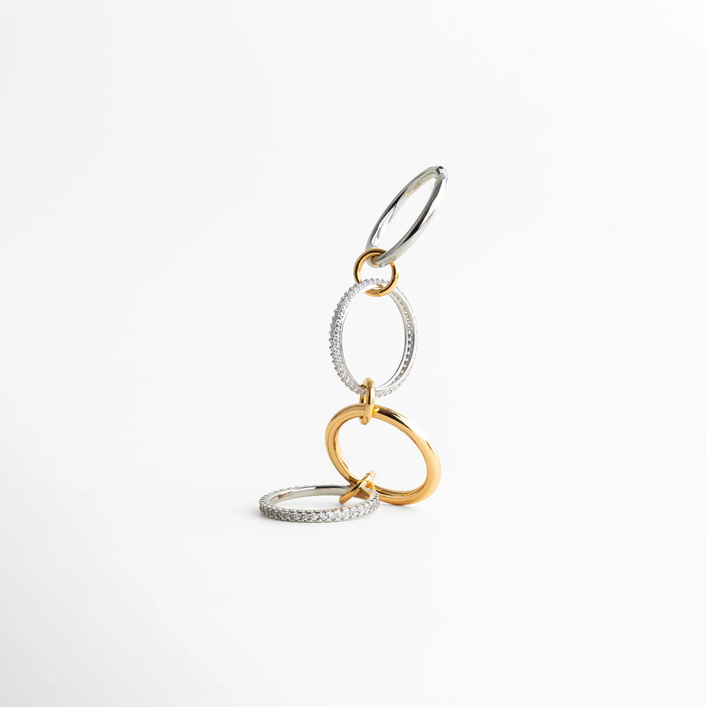 Vista vertical del anillo bicolor con aros entrelazados en tonos dorado y plateado, diseño contemporáneo con contraste sofisticado.