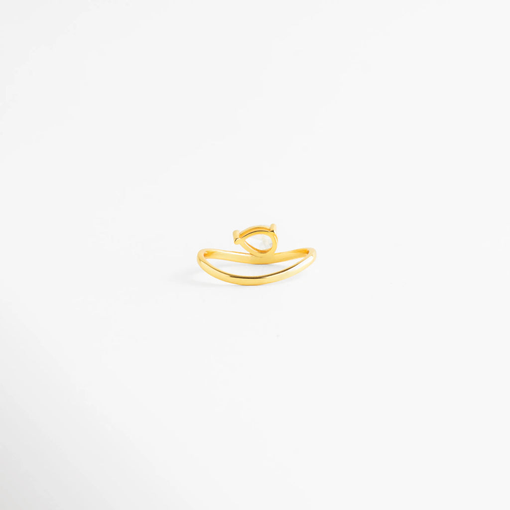 Anillo de plata ley 925 con zirconia central en composición minimalista, Vista general de sortija dorada con piedra brillante sobre fondo blanco, Anillo de compromiso sencillo o promesa en plata con baño de oro, Joyería contemporánea de plata 925 con diseño de línea curva, Detalle de anillo solitario moderno con zirconia de 0.8 cm de largo.